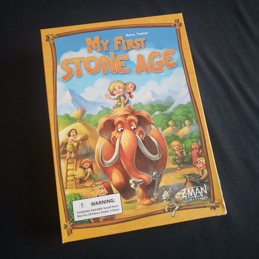 Image shows the front cover of the box of the My First Stone Age board game