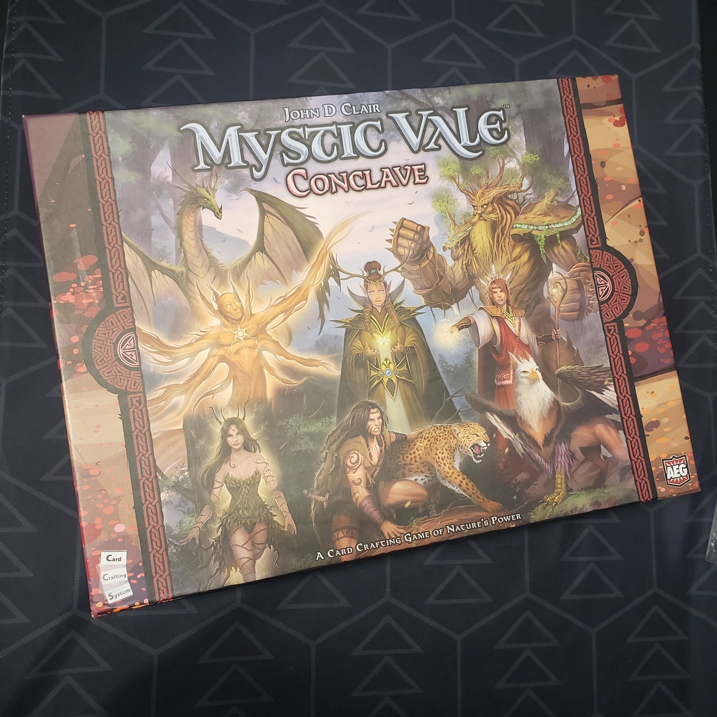Image shows the front cover of the box of the Conclave expansion + storage box for the board game Mystic Vale