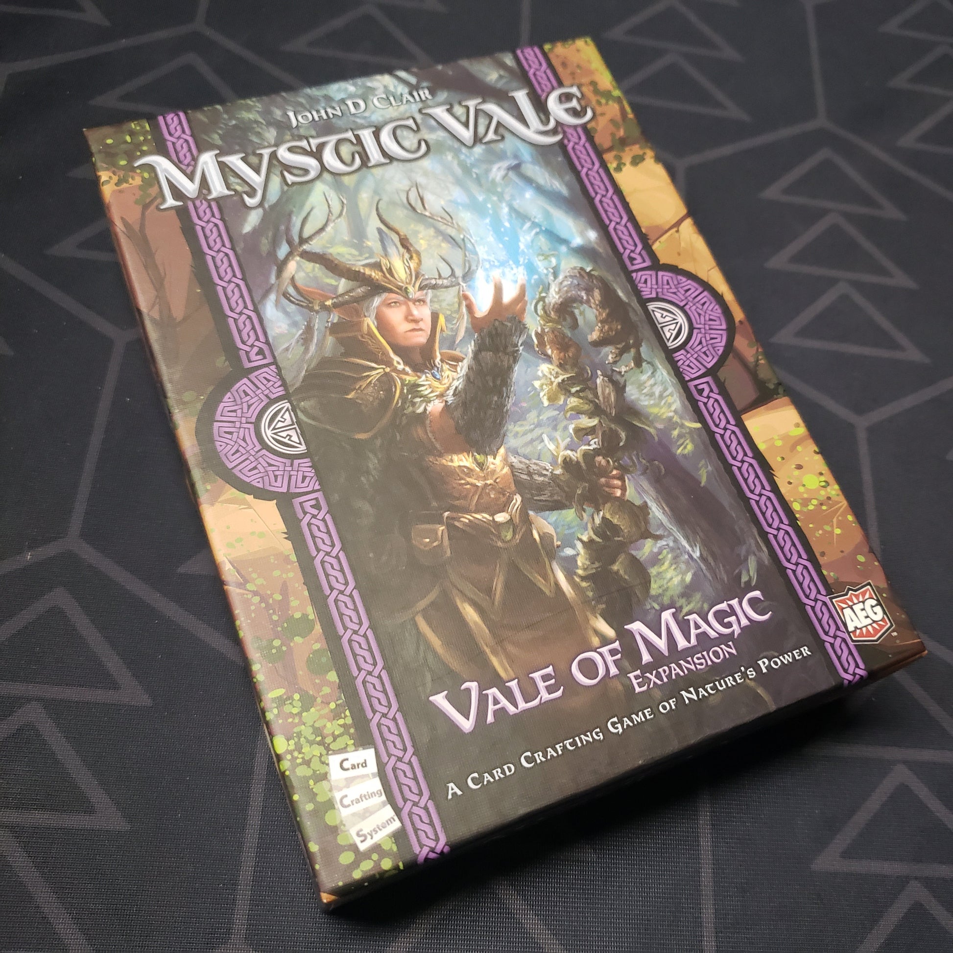 Image shows the front cover of the box of the Vale of Magic expansion for the card game Mystic Vale