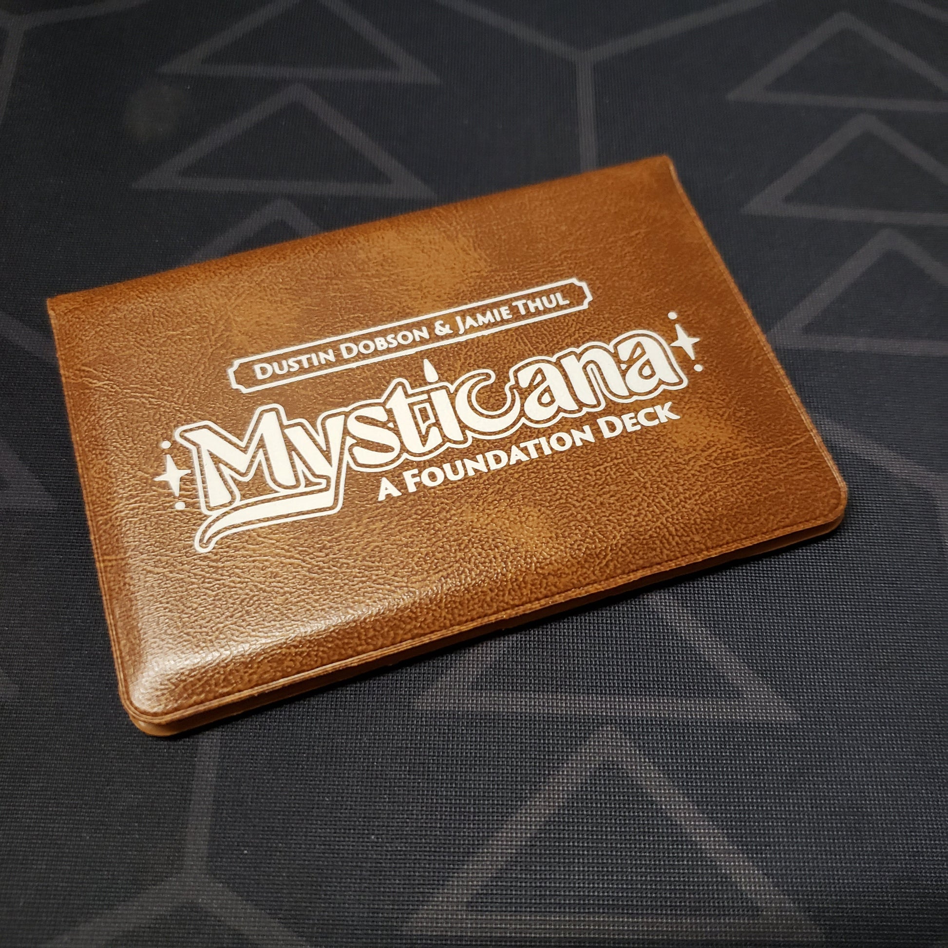 Image shows the front of the card wallet for the card game Mysticana: A Foundation Deck