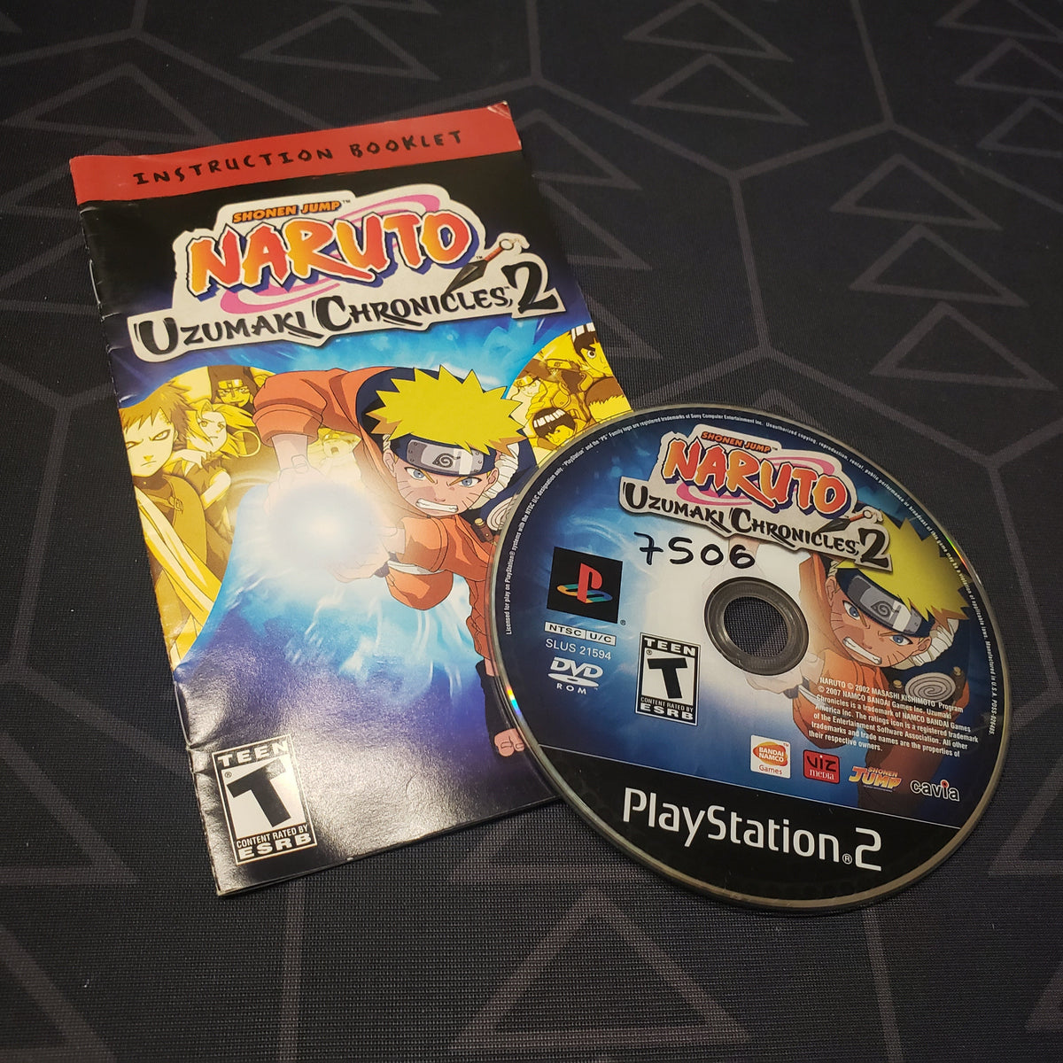 Image shows the manual and disc for the video game Naruto: Uzumaki Chronicles 2 for Playstation 2