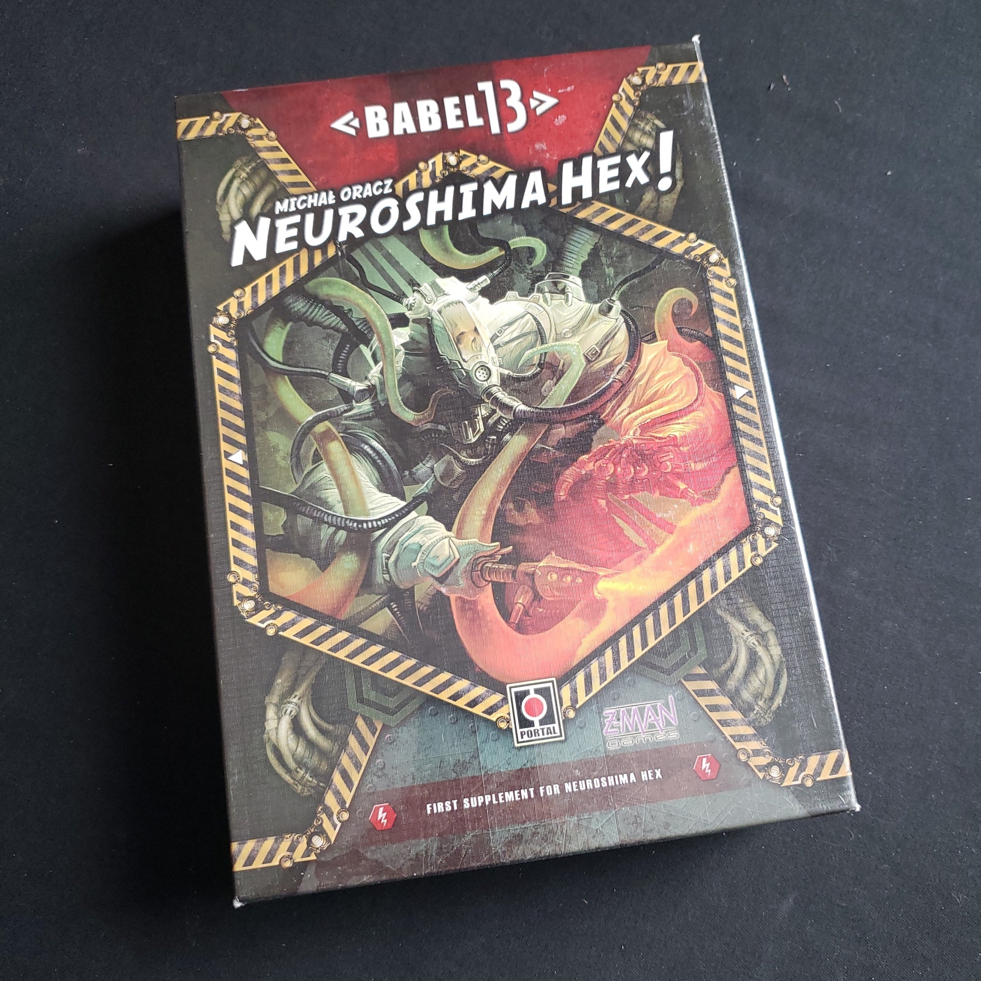 Image shows the front cover of the box of the Babel13 expansion for the board game Neuroshima Hex!
