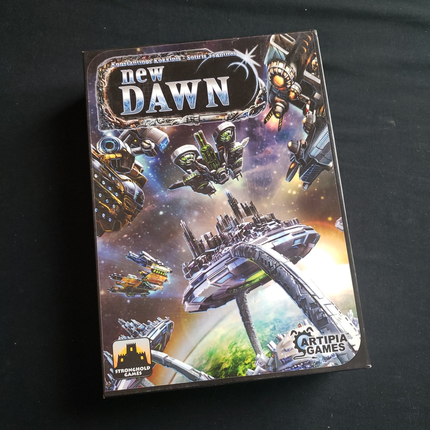 Image shows the front cover of the box of the New Dawn board game
