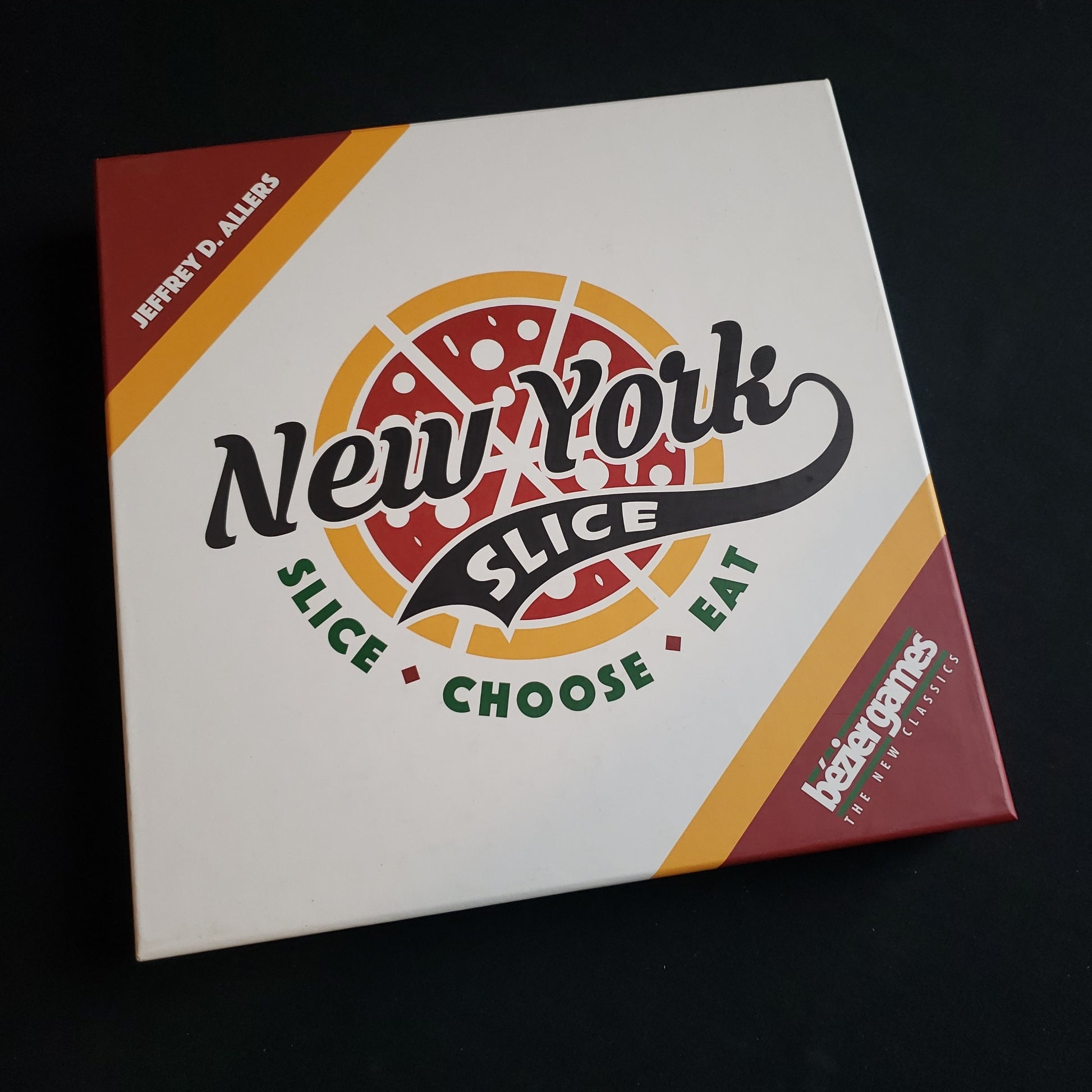 Image shows the front cover of the box of the New York Slice board game