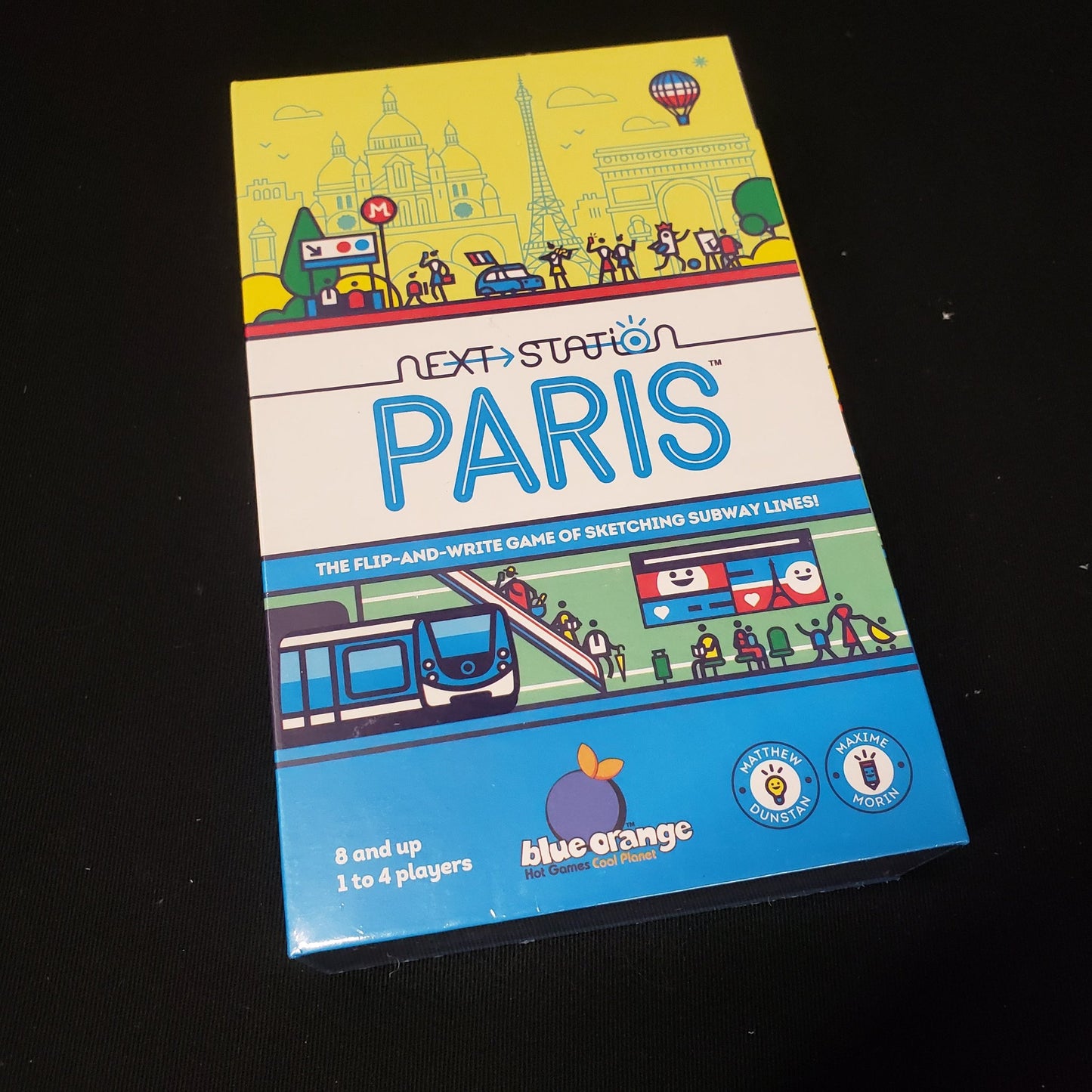 Image shows the front cover of the box of the Next Station: Paris board game