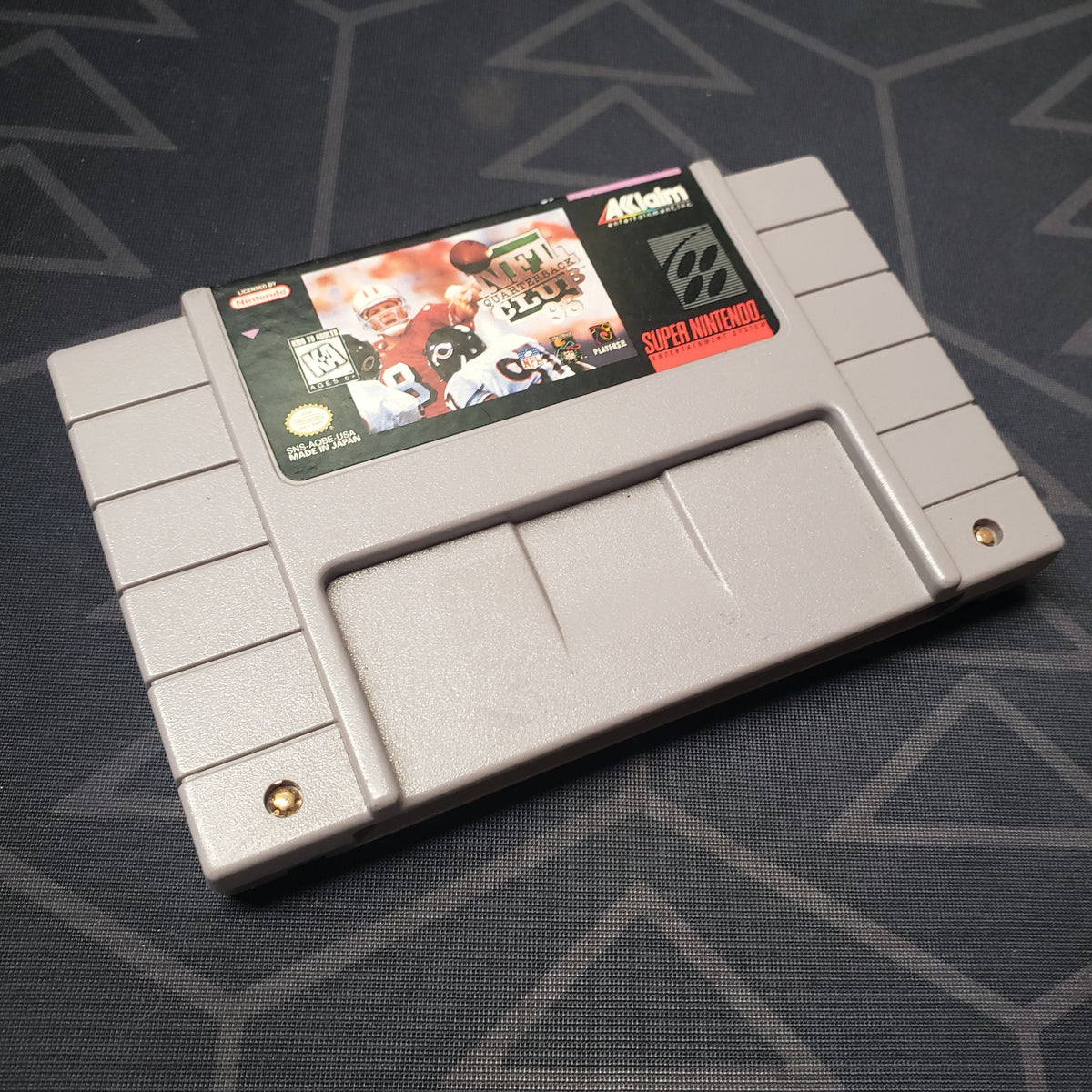 Image shows the front of the cartridge for the video game NFL Quarterback Club 96 for the Super Nintendo
