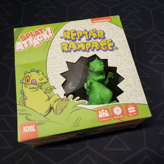 Image shows the front cover of the box of the Reptar Rampage expansion for the board game Nickelodeon Splat Attack!