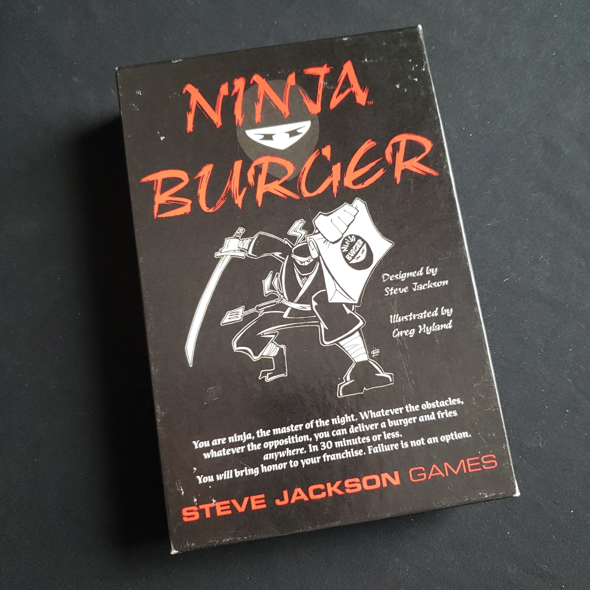 Image shows the front cover of the box of the Ninja Burger card game