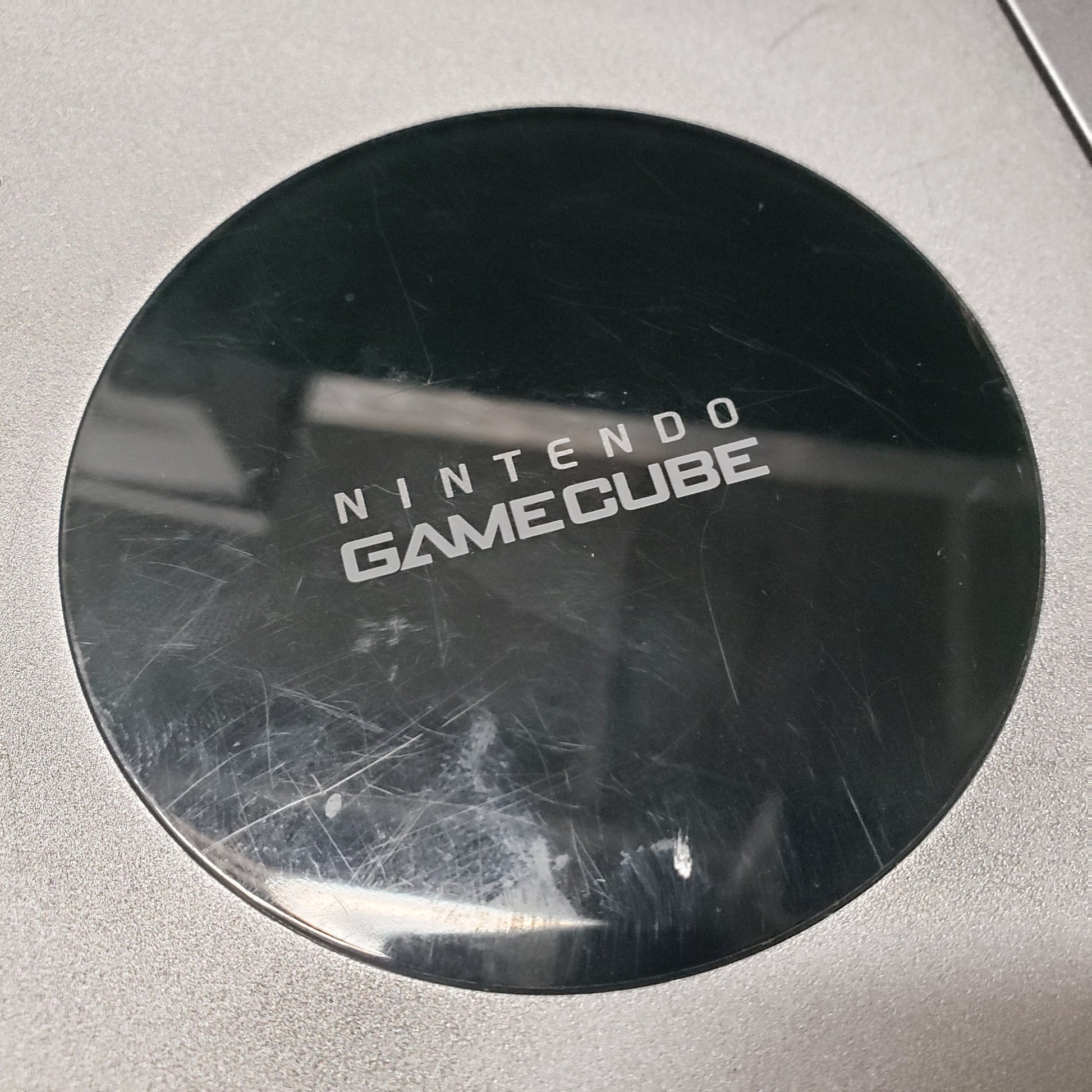 Image shows some light scratches on the glossy top part of a platinum color Nintendo GameCube gaming console