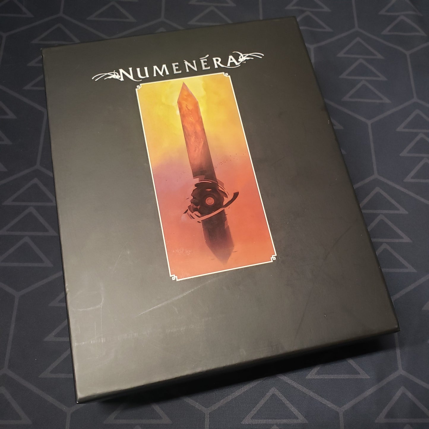 Image shows the front cover of the Deck Box storage box for the roleplaying game Numenera