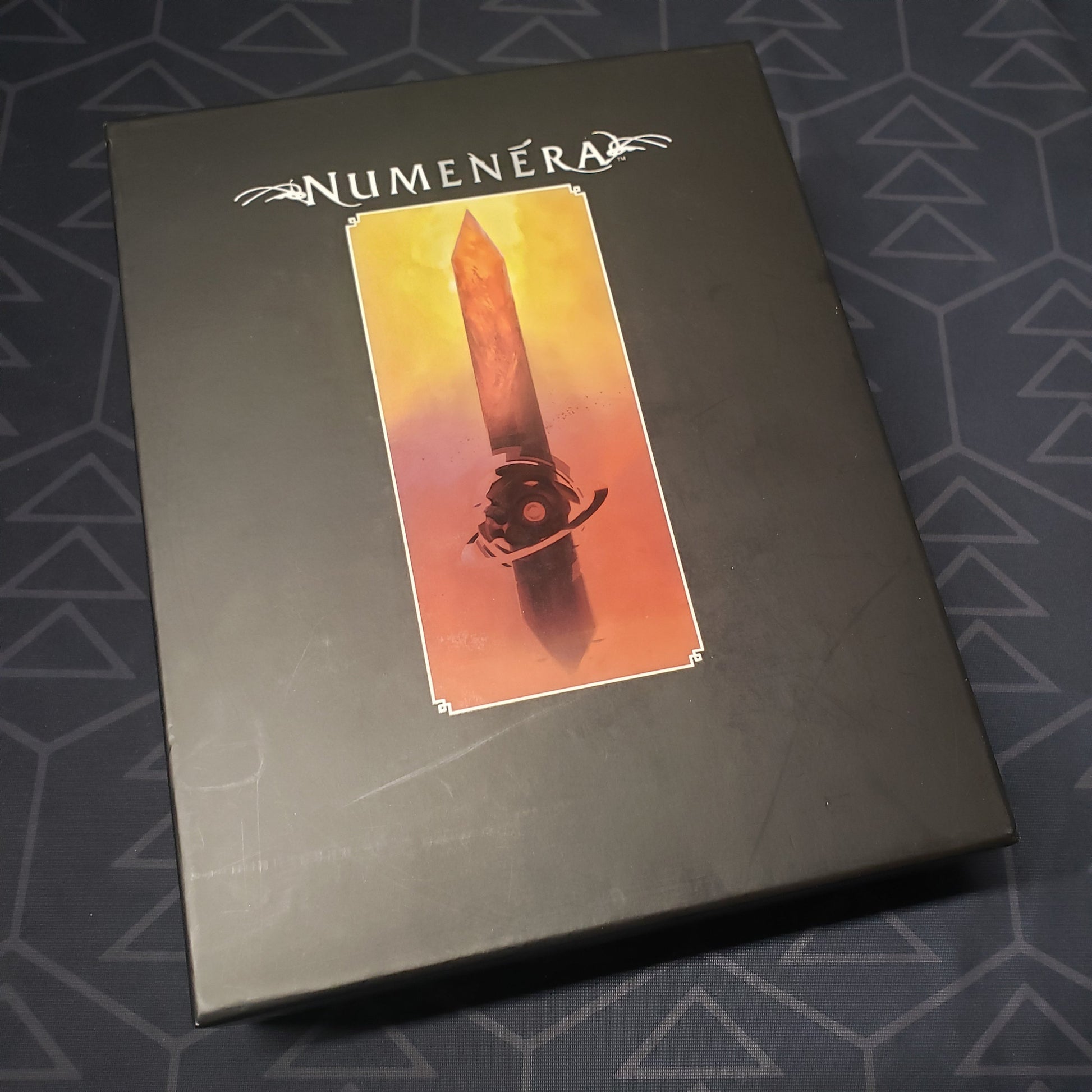 Image shows the front cover of the Deck Box storage box for the roleplaying game Numenera