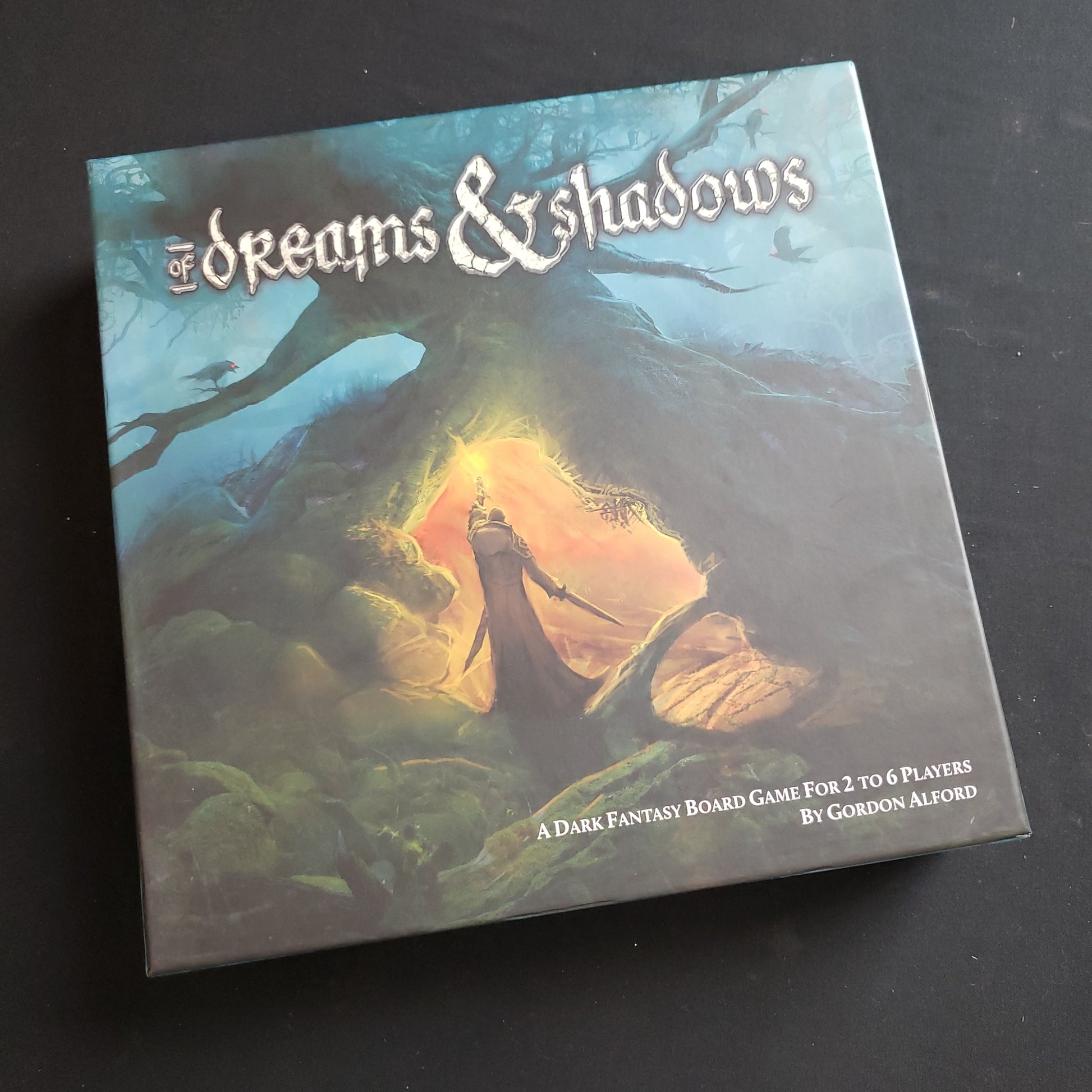 Image shows the front cover of the box of the board game Of Dreams & Shadows