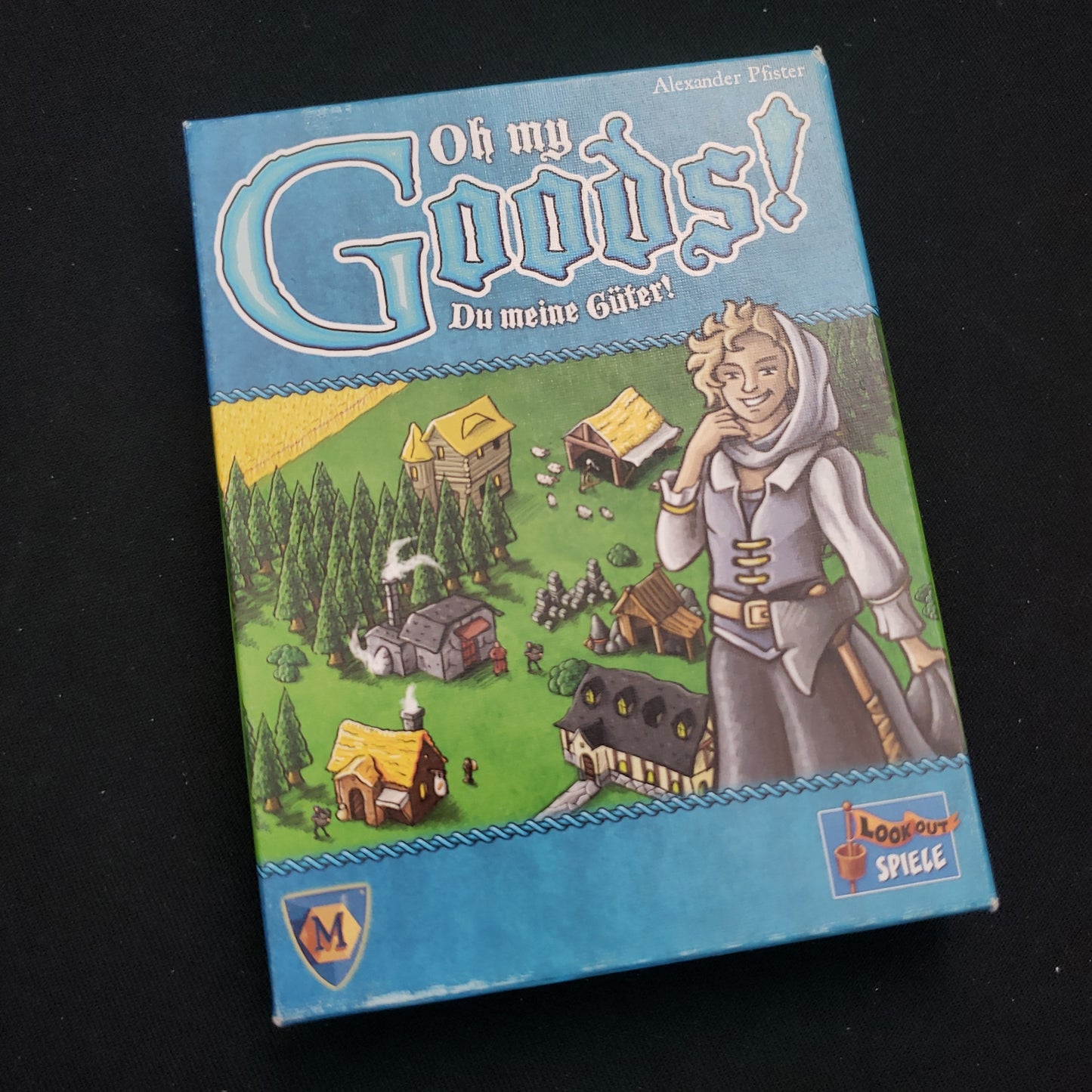 Image shows the front cover of the box of the Oh My Goods card game