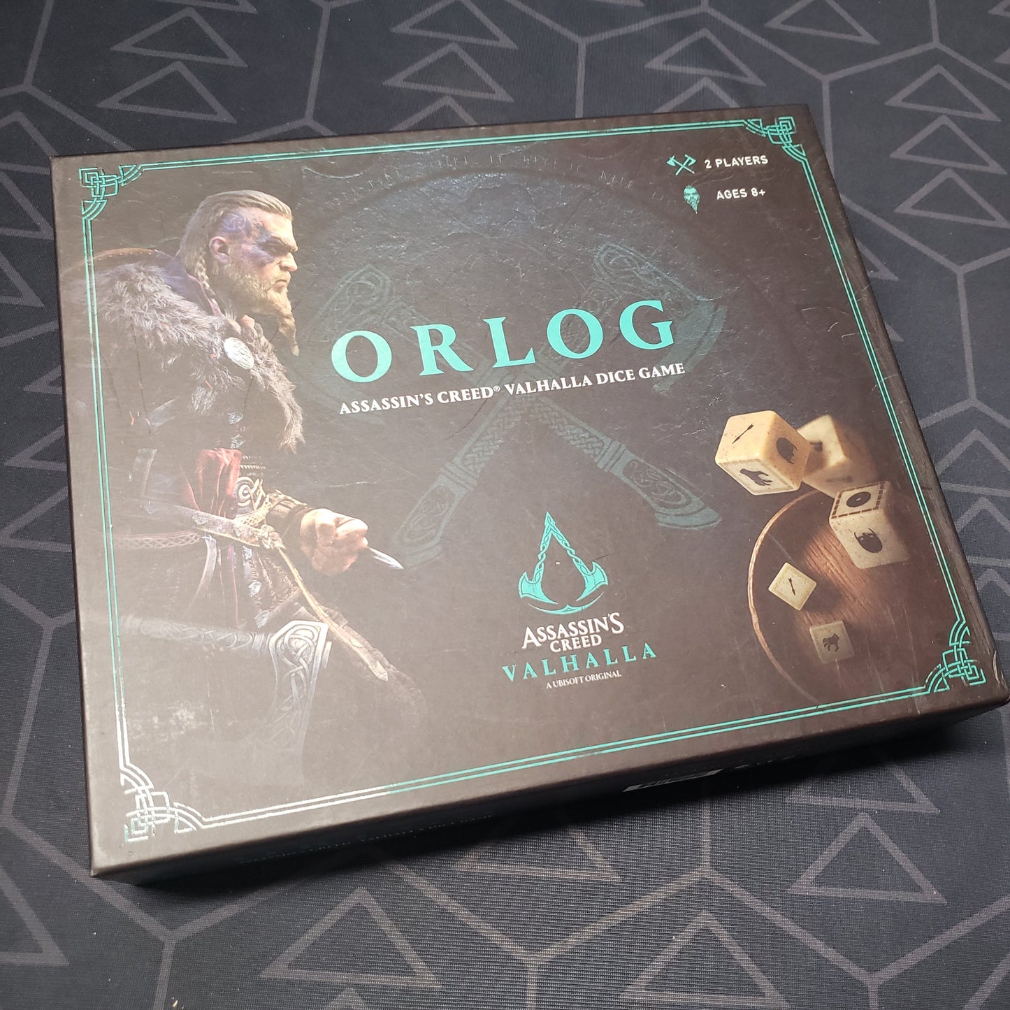 Image shows the front cover of the box for the Orlog: Assassin's Creed Valhalla Dice Game