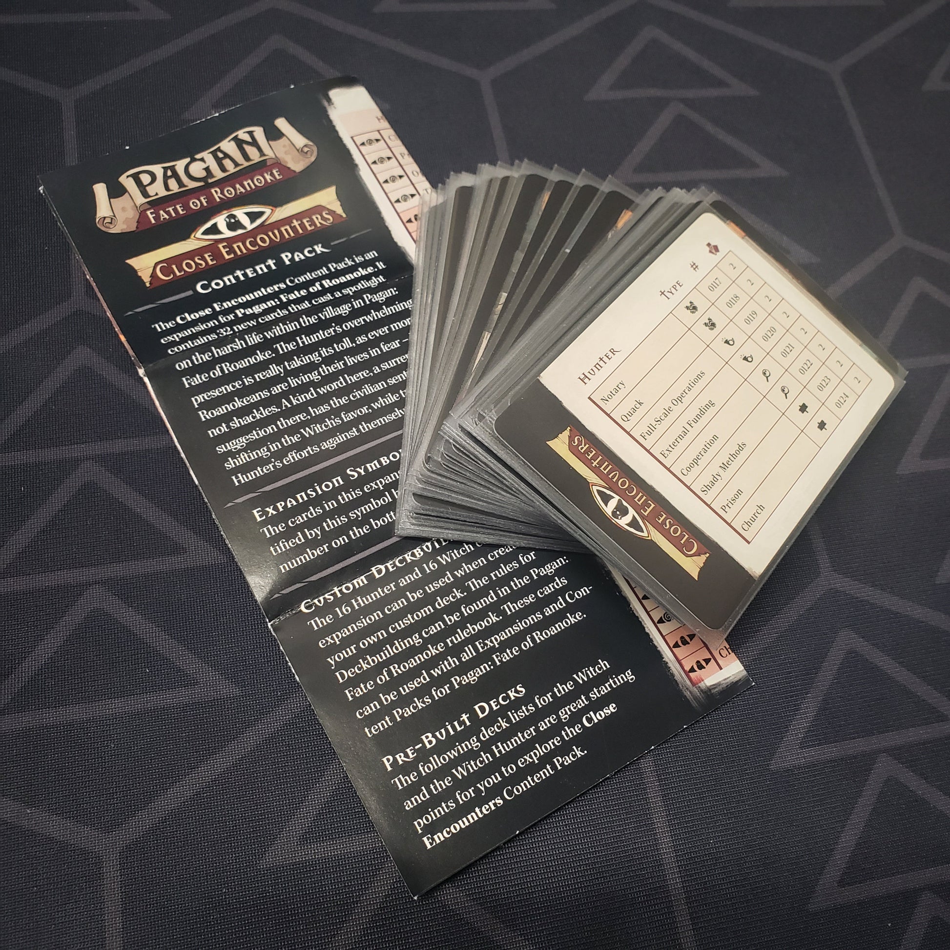 Image shows the fanned-out cards & instruction sheet for the Close Encounters Content Pack expansion for the card game Pagan: Fate of Roanoke