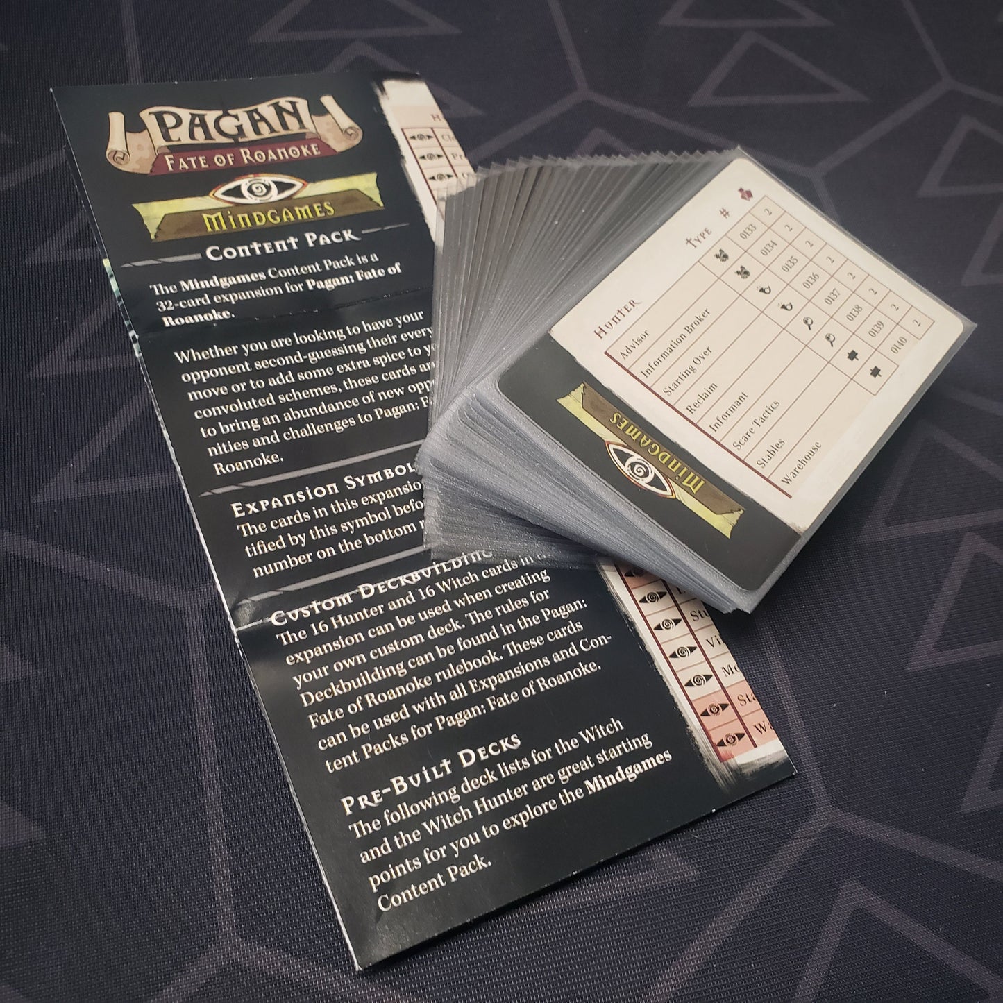 Image shows the fanned-out cards & instruction sheet for the Mindgames Content Pack expansion for the card game Pagan: Fate of Roanoke