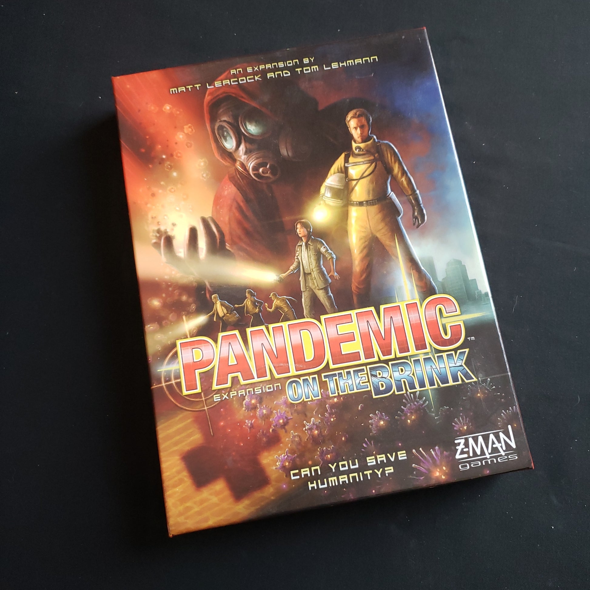 Image shows the front cover of the box of the On the Brink expansion for the Pandemic board game