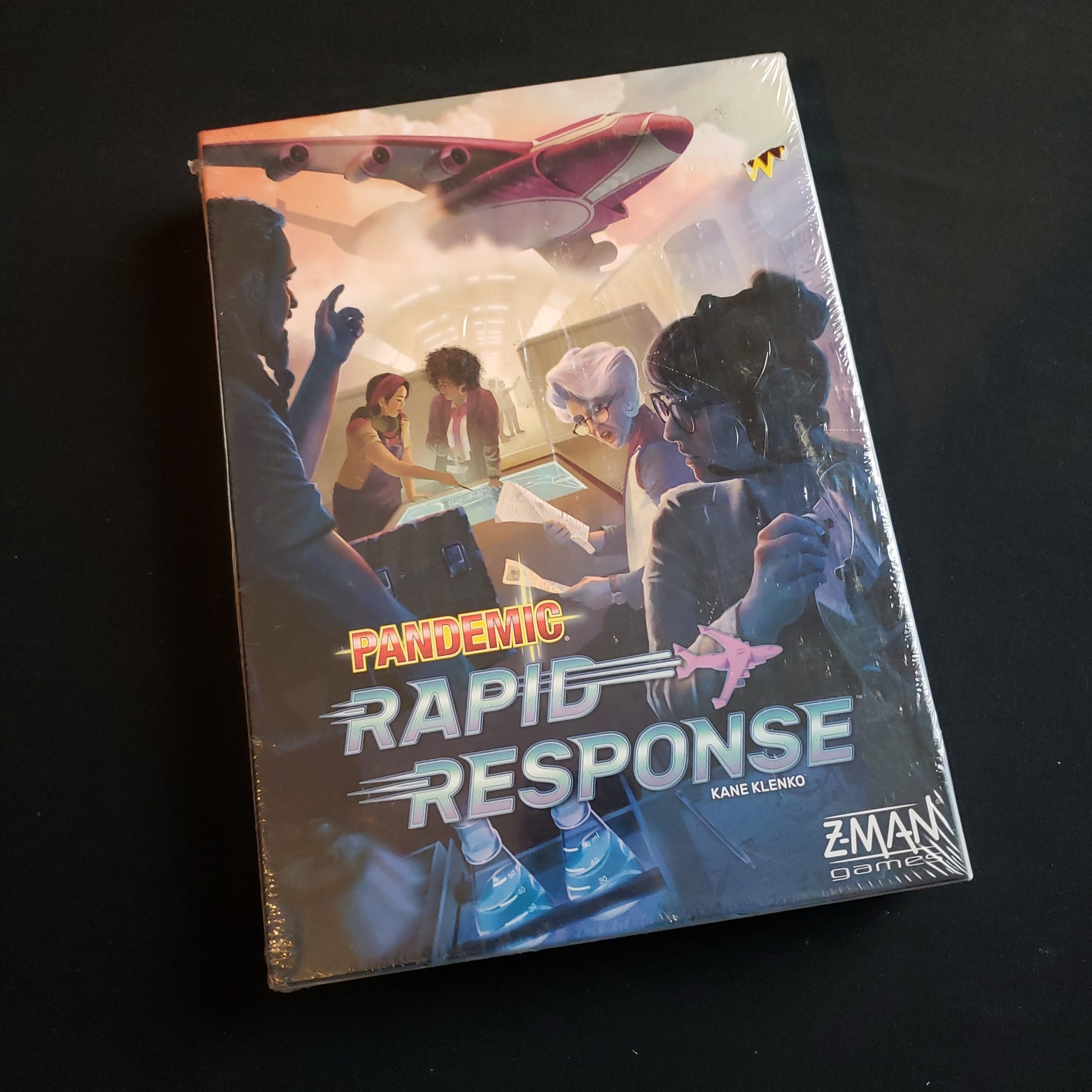 Image shows the front cover of the box of the Pandemic: Rapid Response board game