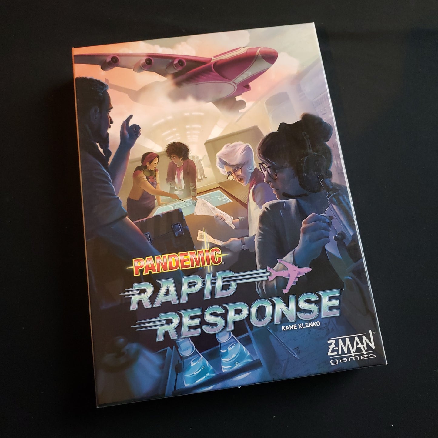 Image shows the front cover of the box of the Pandemic: Rapid Response board game