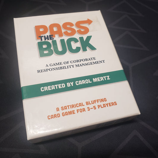 Image shows the front cover of the box for the card game Pass the Buck: A Game of Corporate Responsibility Management
