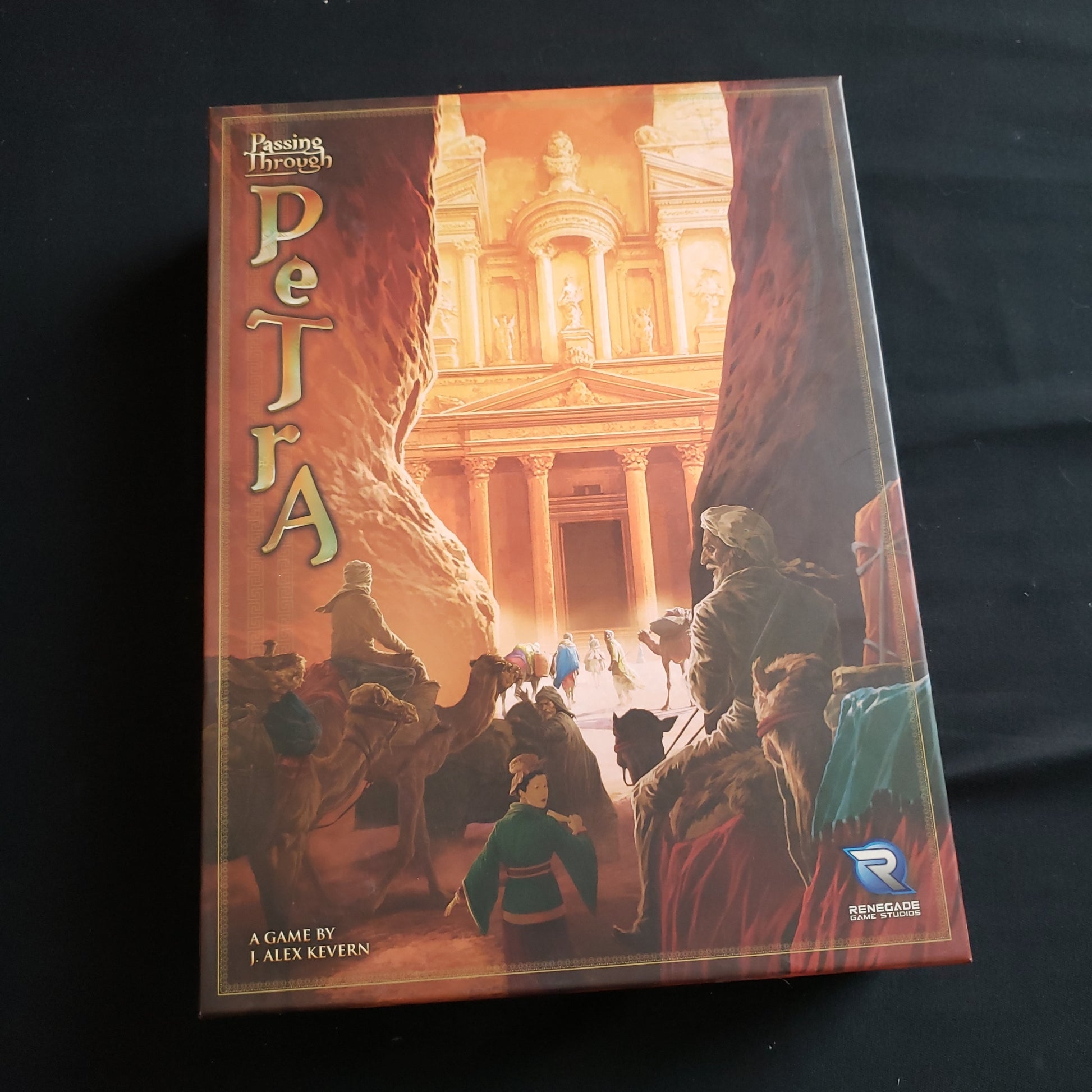 Image shows the front cover of the box of the Passing Through Petra board game