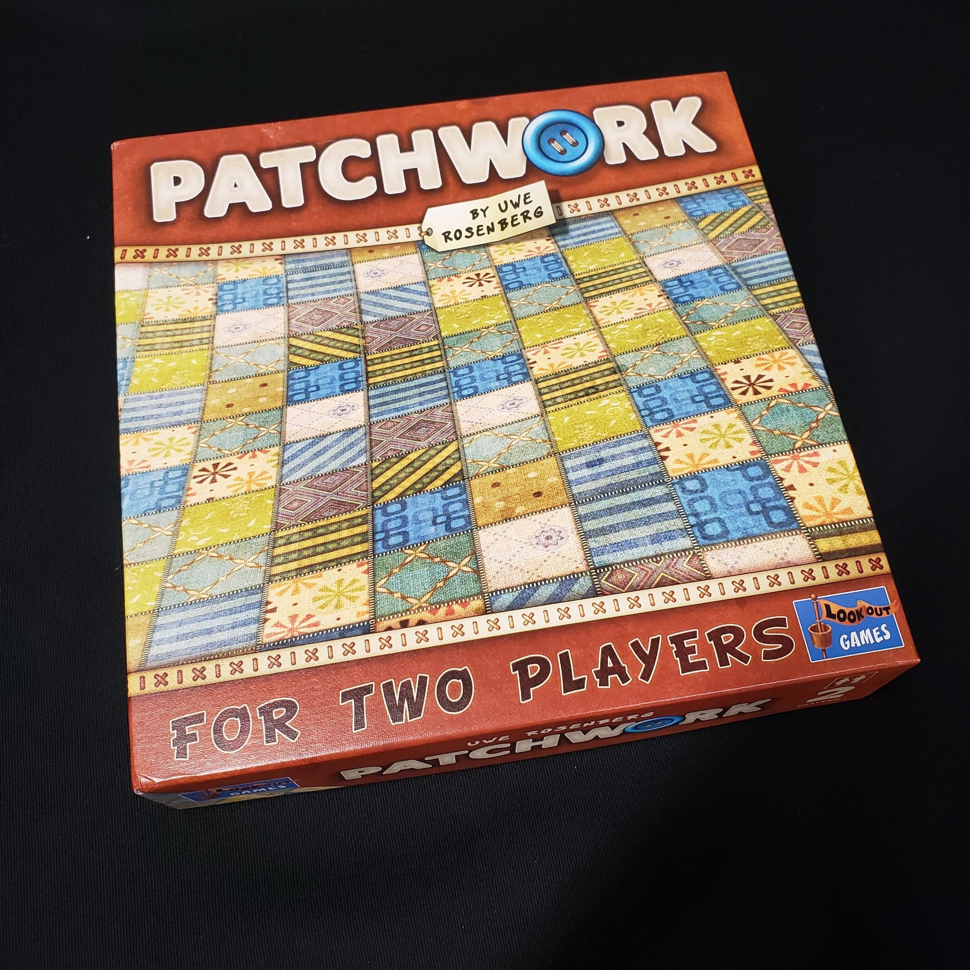 Image shows the front cover of the box of the Patchwork board game