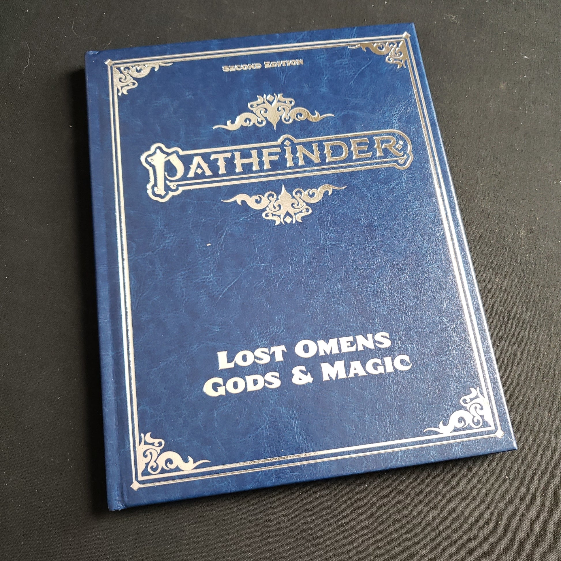 Image shows the front cover of the special edition Lost Omens: Gods & Magic book for the Pathfinder Second Edition roleplaying game