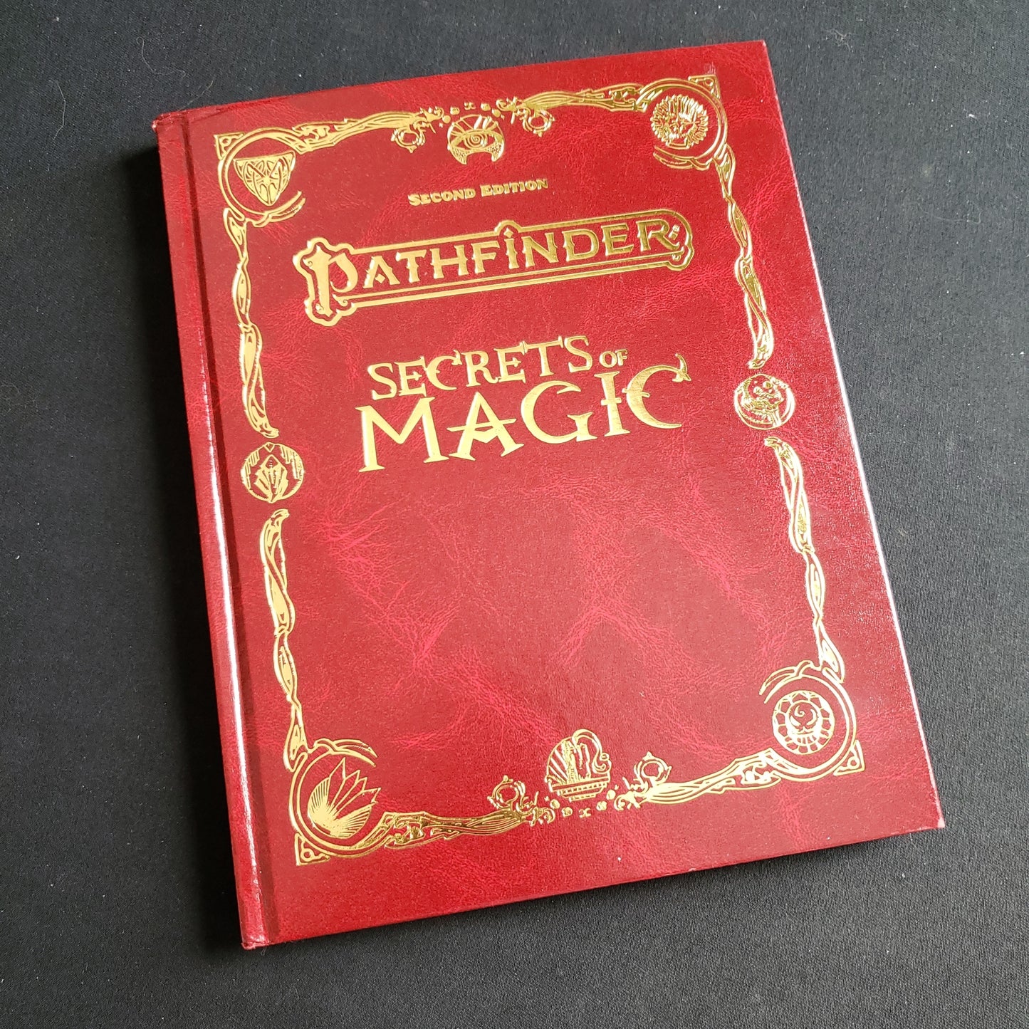 Image shows the front cover of the special edition Secrets Of Magic book for the Pathfinder Second Edition roleplaying game