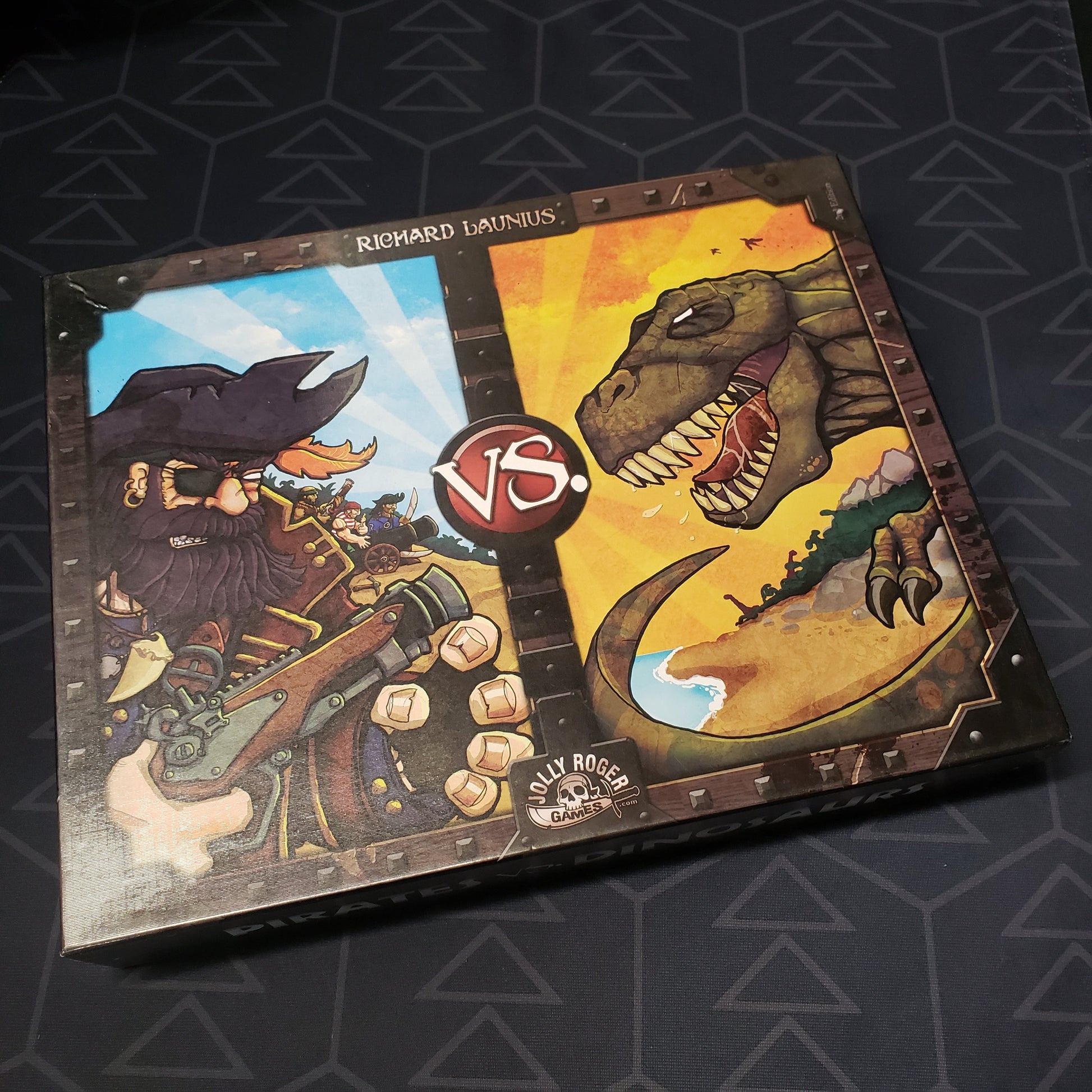 Image shows the front cover of the box of the Pirates vs. Dinosaurs board game