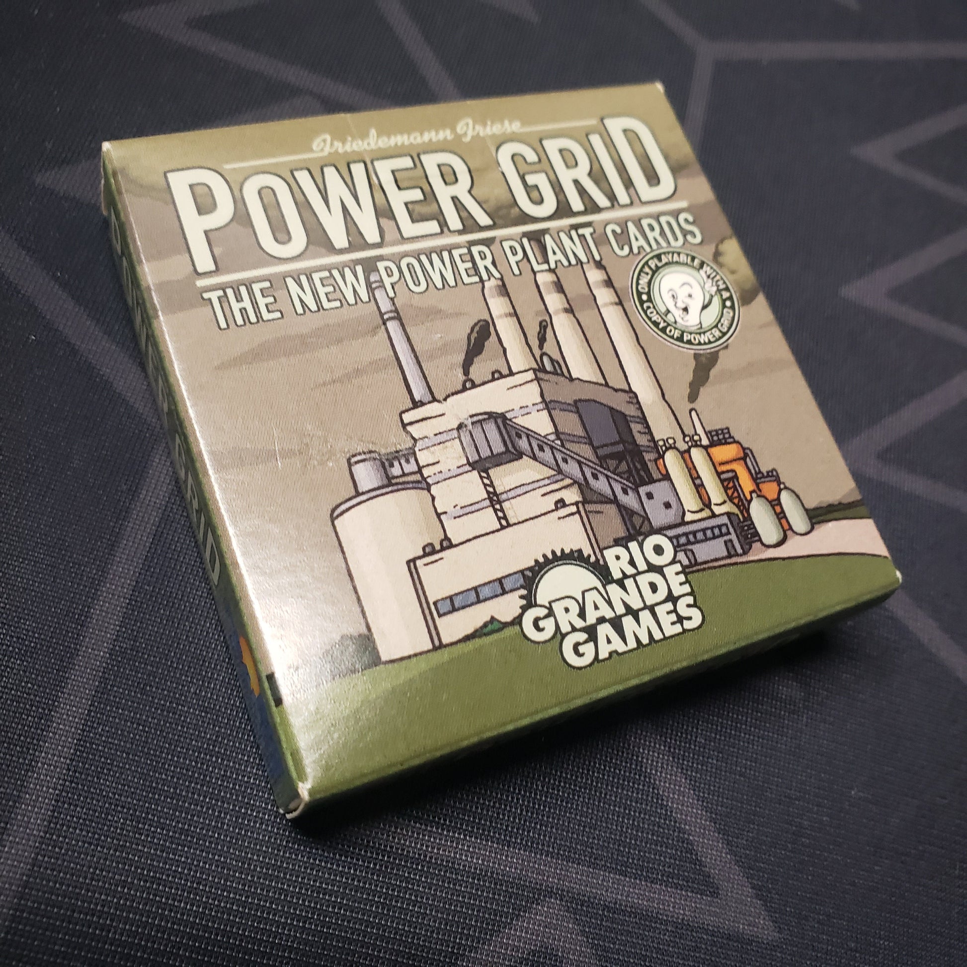 Image shows the front cover of the box of the New Power Plant Cards expansion for the board game Power Grid