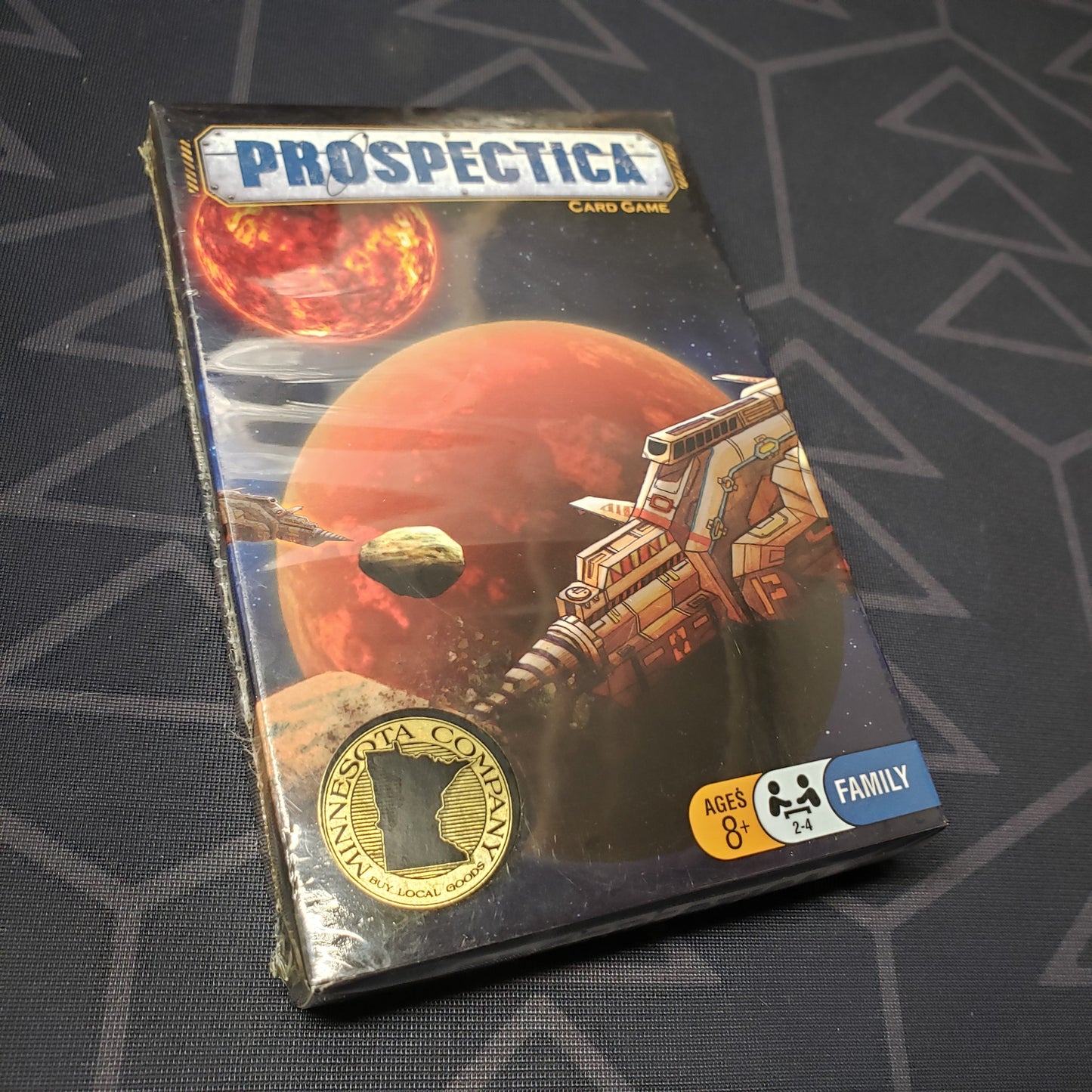 Image shows the front cover of the box for the Prospectica card game