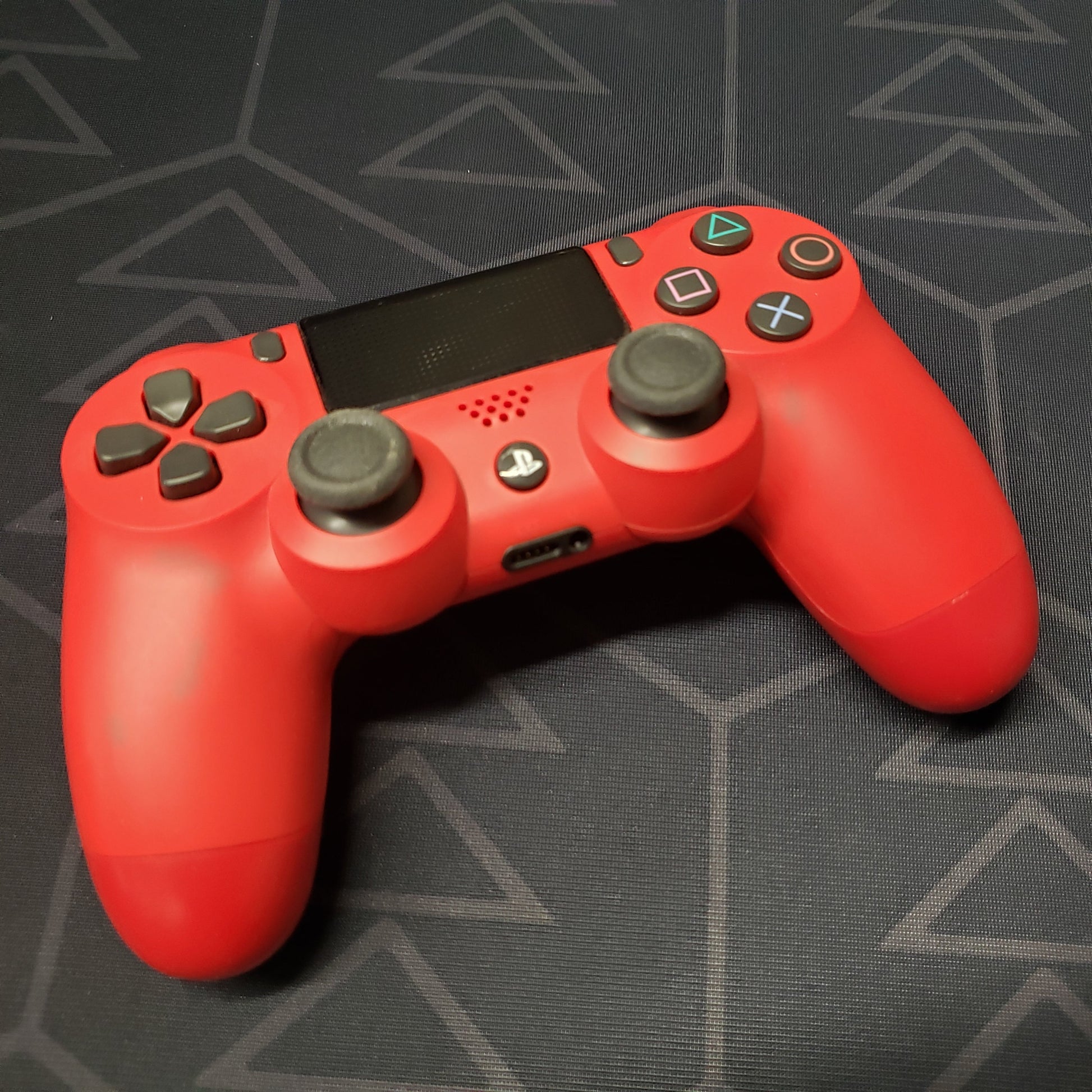 Image shows the top of a red DualShock 4 controller for Playstation 4