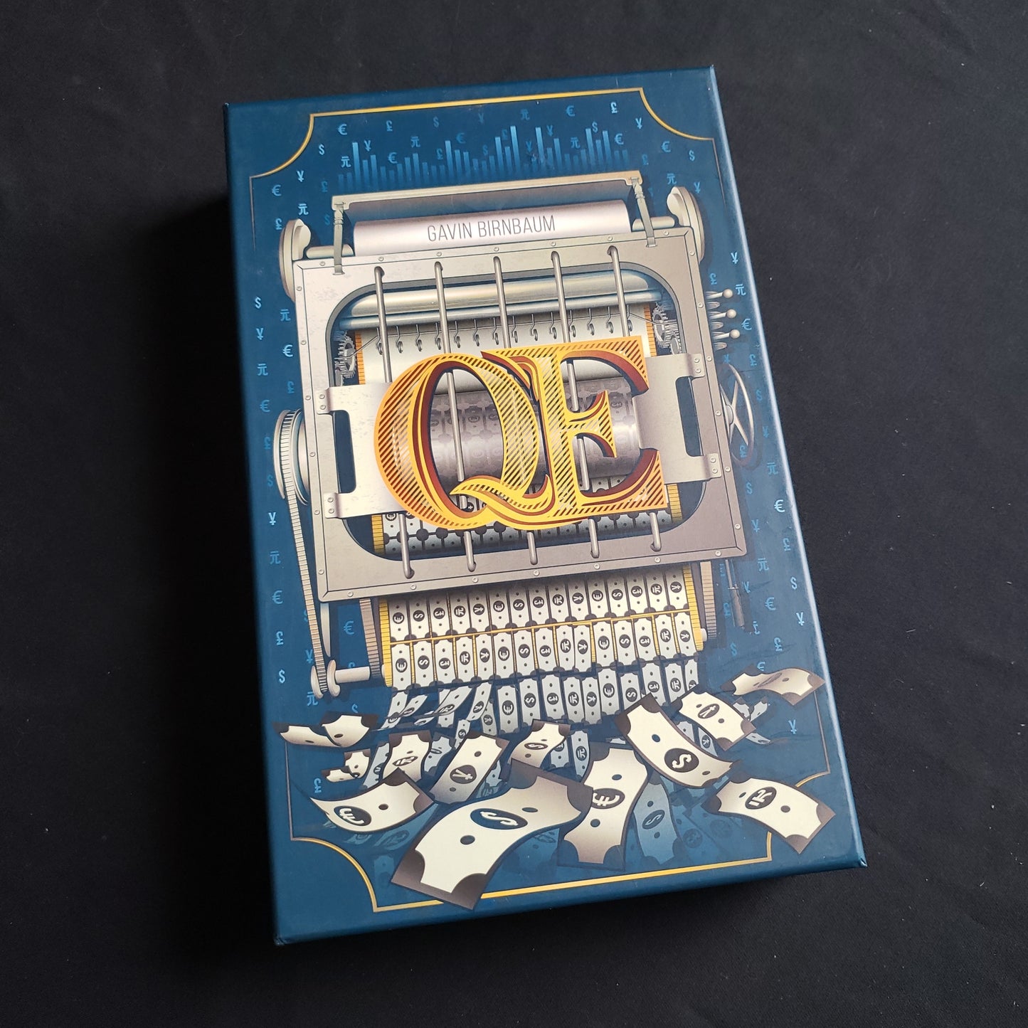 Image shows the front cover of the box of the QE board game