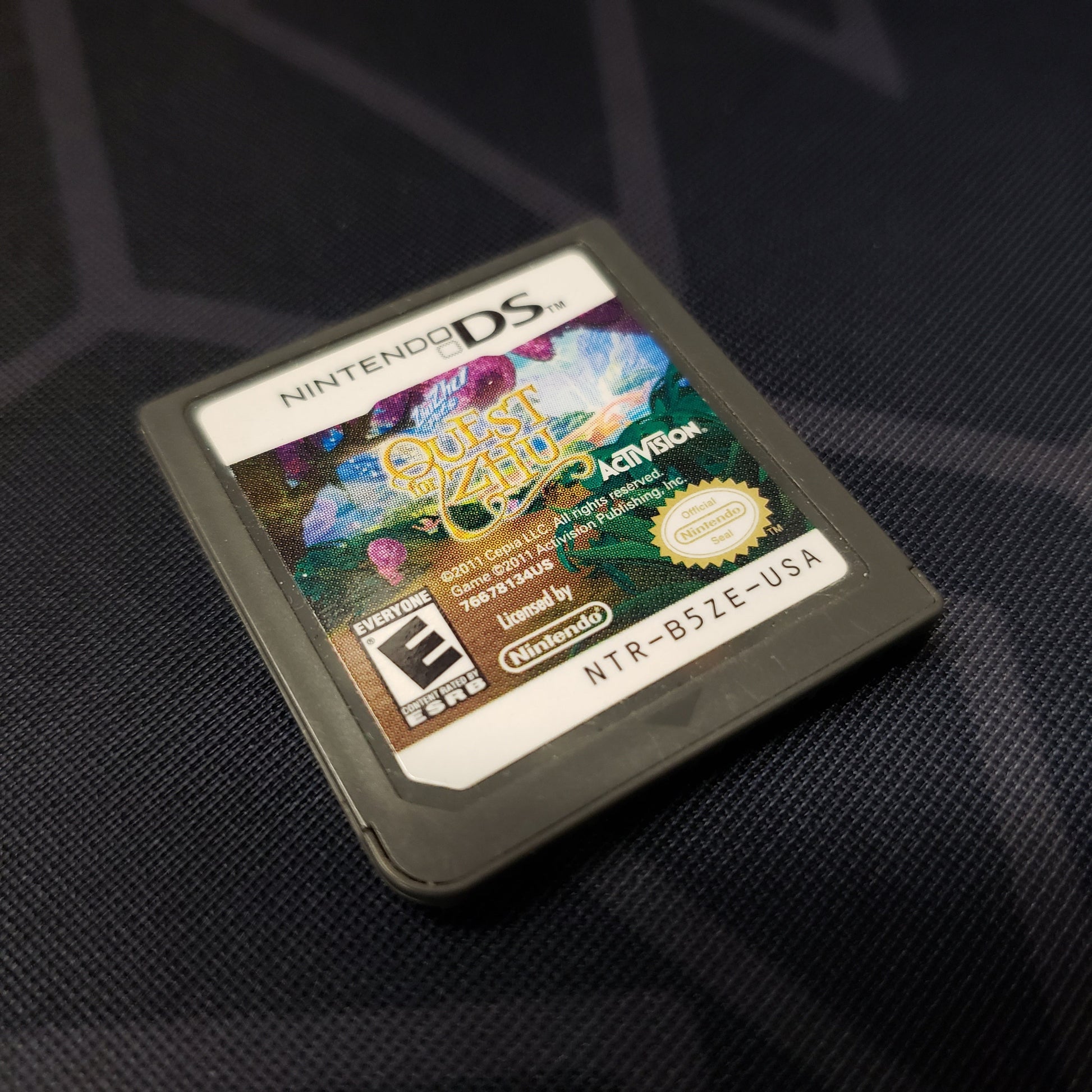 Image shows the front of the cartridge for the video game Quest for Zhu for Nintendo DS