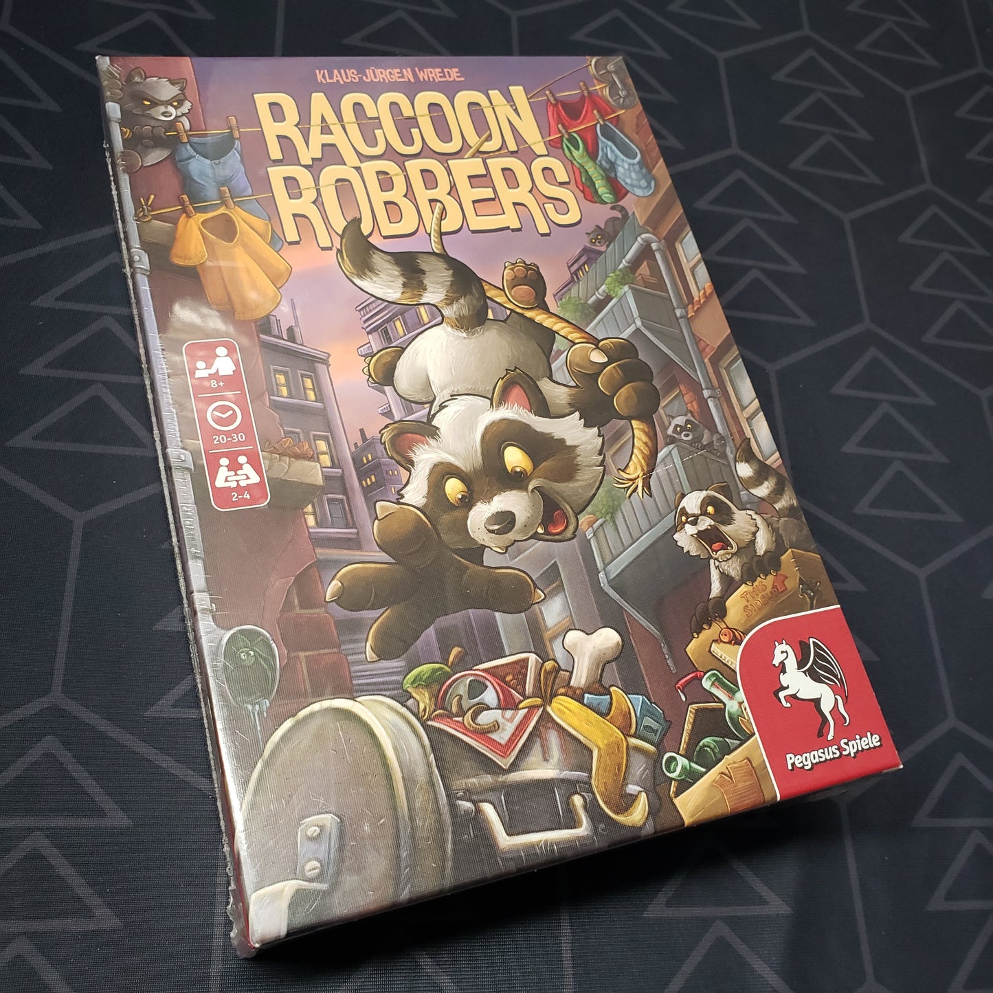 Image shows the front cover of the box for the Raccoon Robbers board game