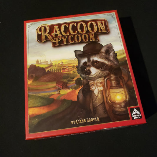 Image shows the front cover of the box of the Raccoon Tycoon board game