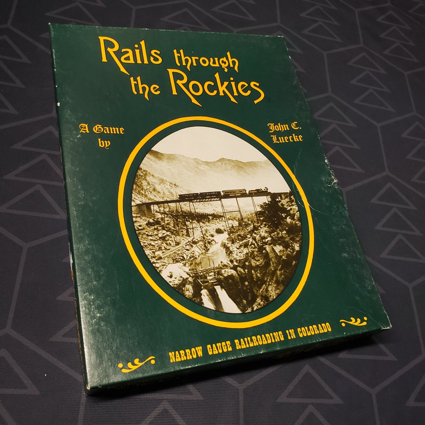 Image shows the front cover of the box for the Rails Through the Rockies board game