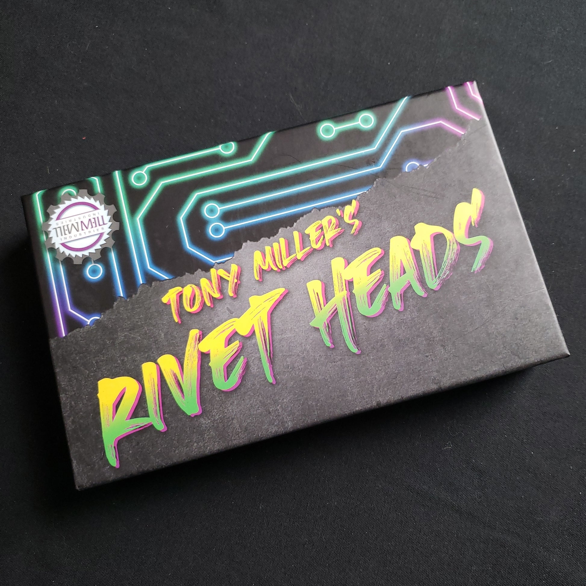 Image shows the front cover of the box of the Rivet Heads card game