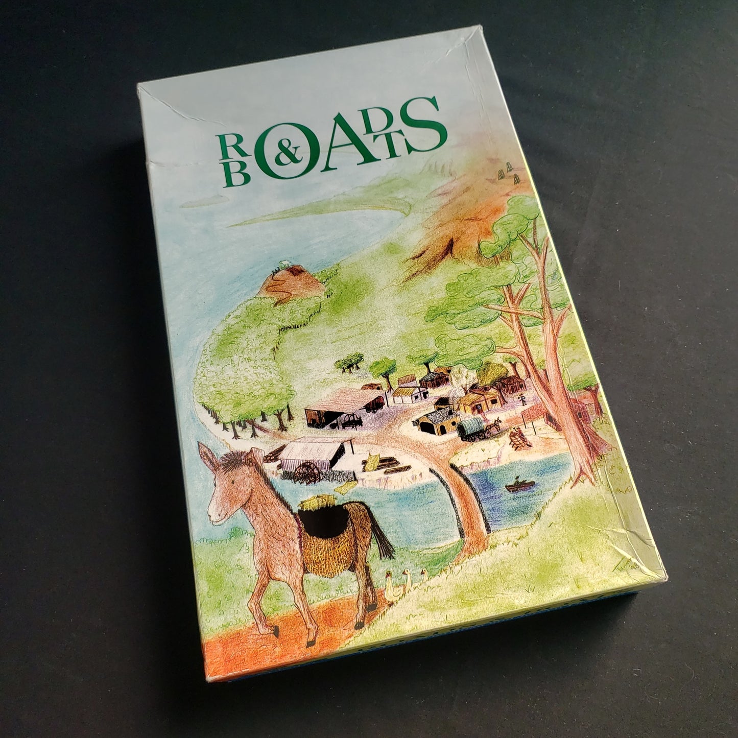 Image shows the front cover of the box of the Roads & Boats board game