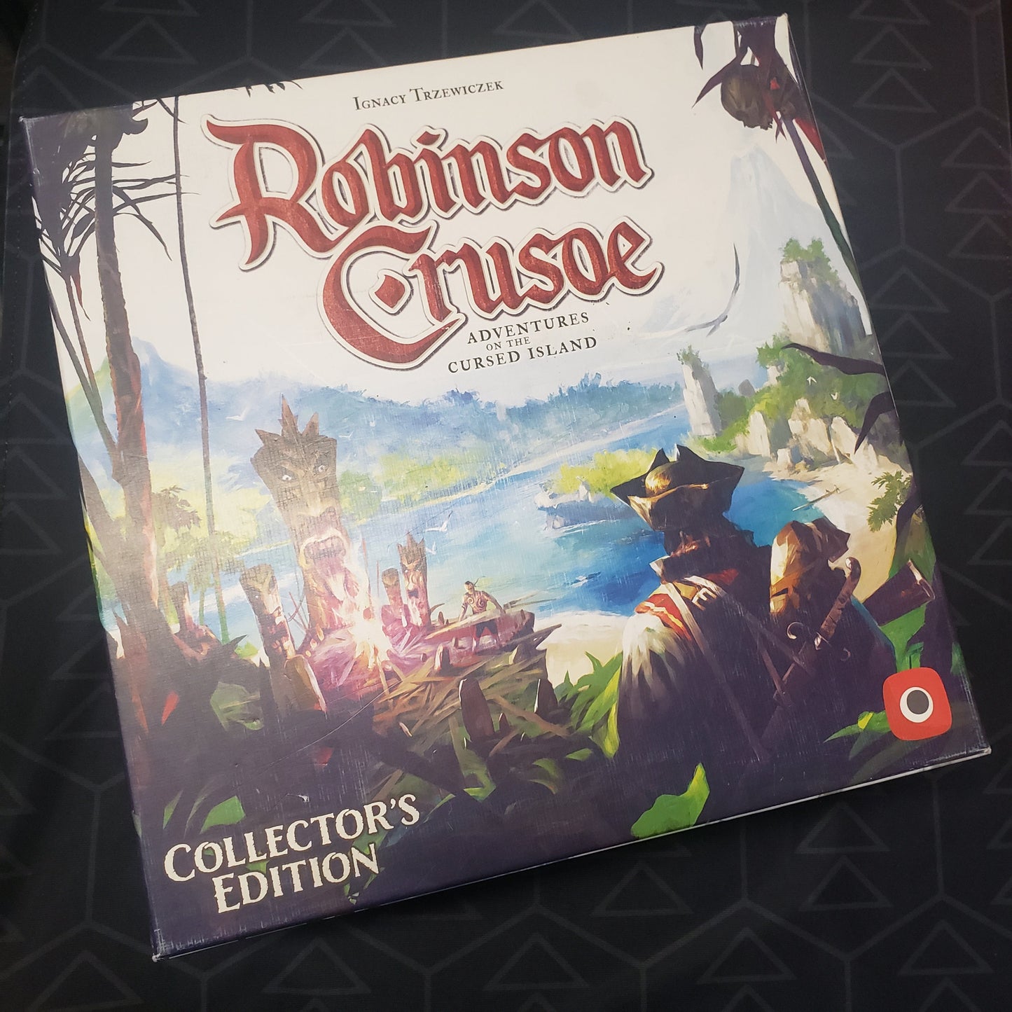 Image shows the front cover of the Collector's Edition box for the board game Robinson Crusoe: Adventures on the Cursed Island