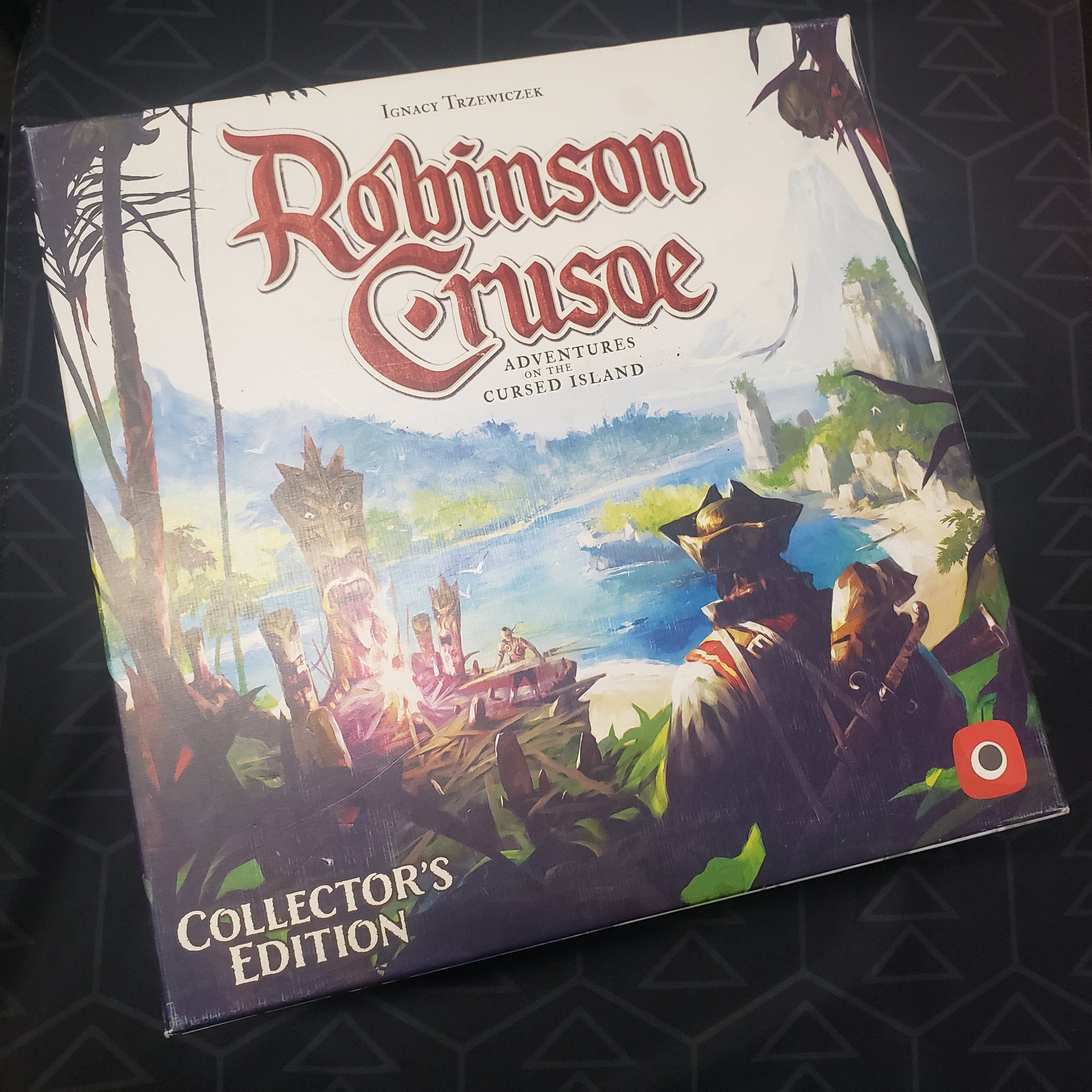 Image shows the front cover of the Collector's Edition box for the board game Robinson Crusoe: Adventures on the Cursed Island