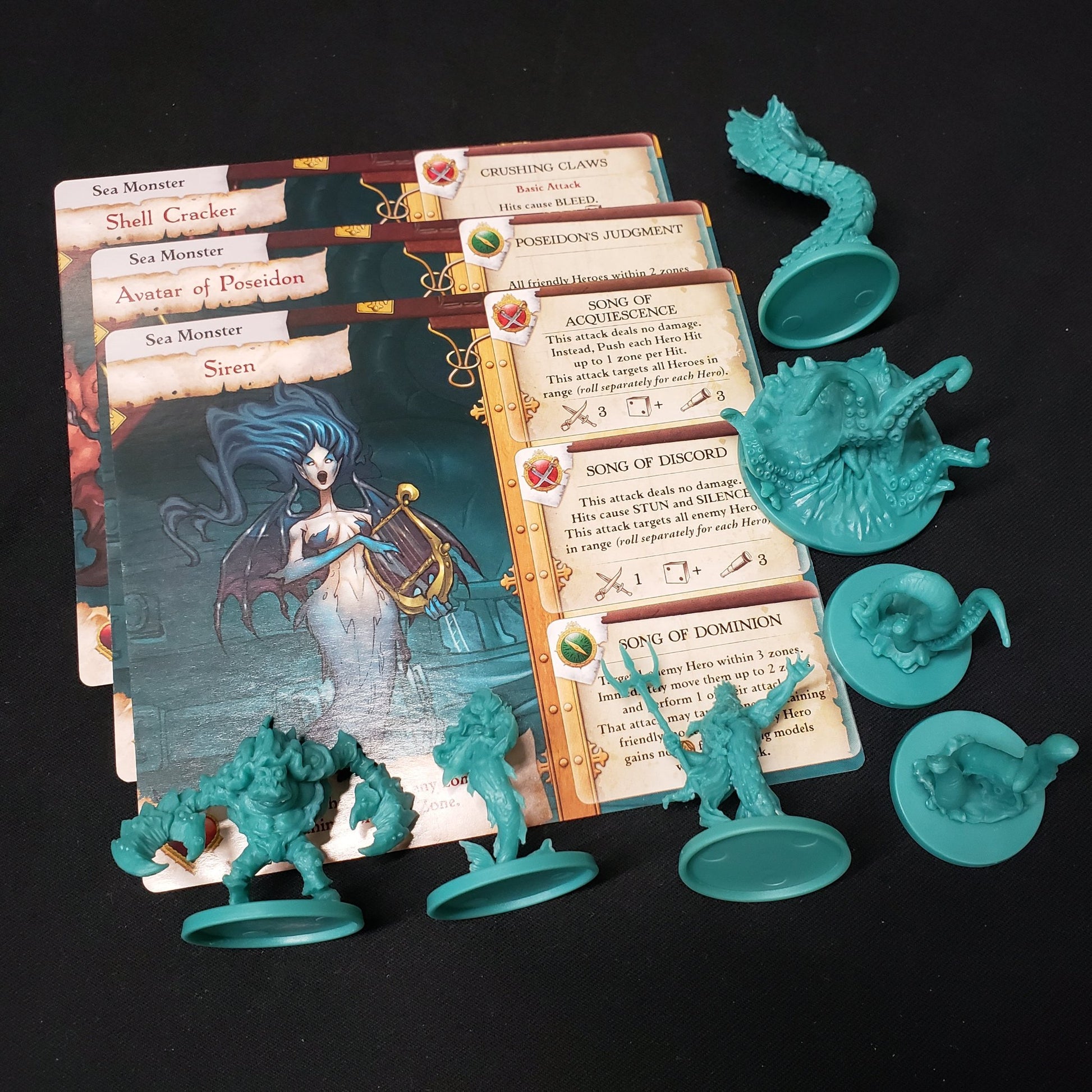 Image shows the miniatures and cards for the Sea Monsters expansion for the board game Rum & Bones: Second Tide