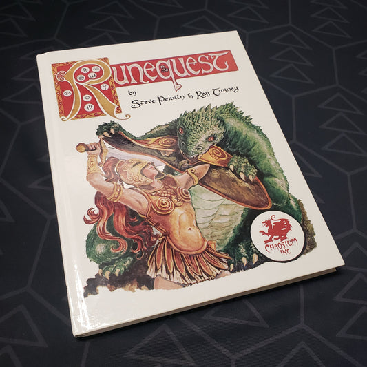 Image shows the front cover of the core rulebook for the roleplaying game RuneQuest 2E