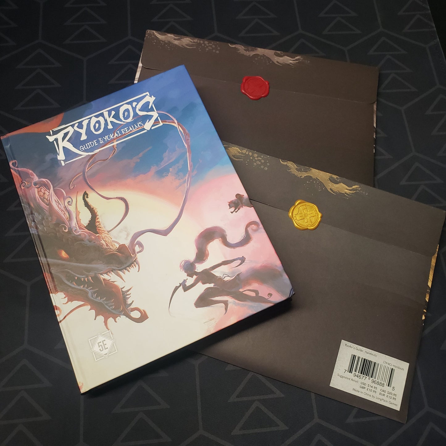 Image shows the front cover of the Ryoko's Guide to the Yokai Realms roleplaying game book with two bonus content envelopes sealed with wax
