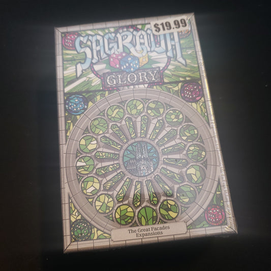 Image shows the front cover of the box of the Glory expansion for the board game Sagrada