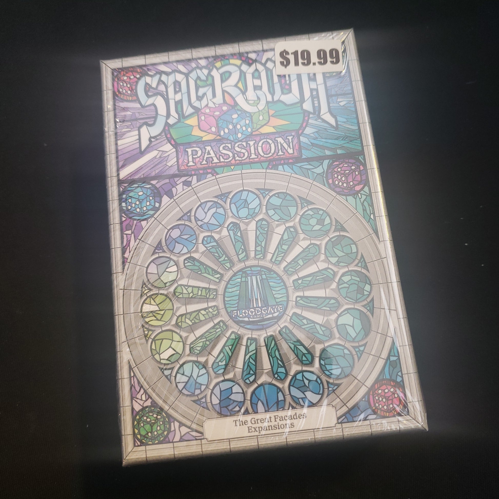 Image shows the front cover of the box of the Passion expansion for the board game Sagrada