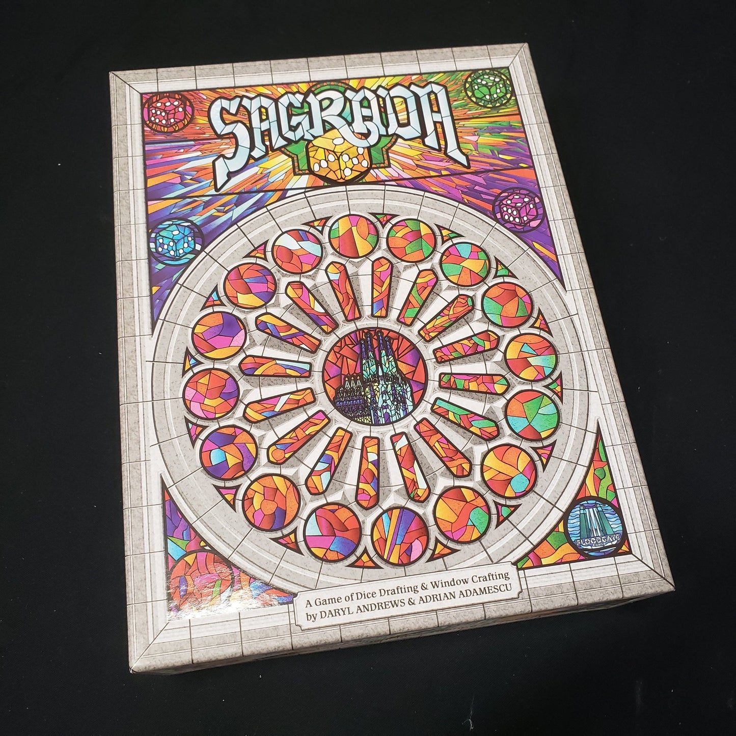 Image shows the front cover of the box of the Sagrada board game