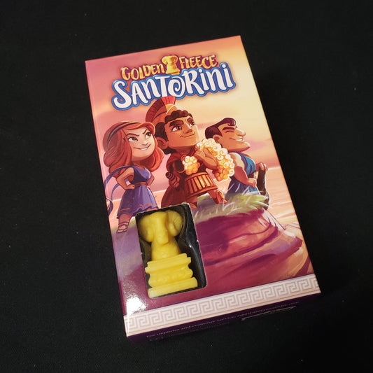 Image shows the front cover of the box of the Golden Fleece expansion for the board game Santorini