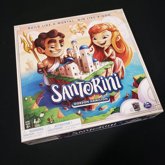 Image shows the front cover of the box of the Santorini board game