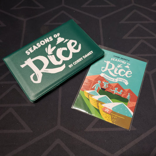 Image shows the front of the card wallet for the Seasons of Rice card game, with the Jasmine & Ginger expansion sitting next to it